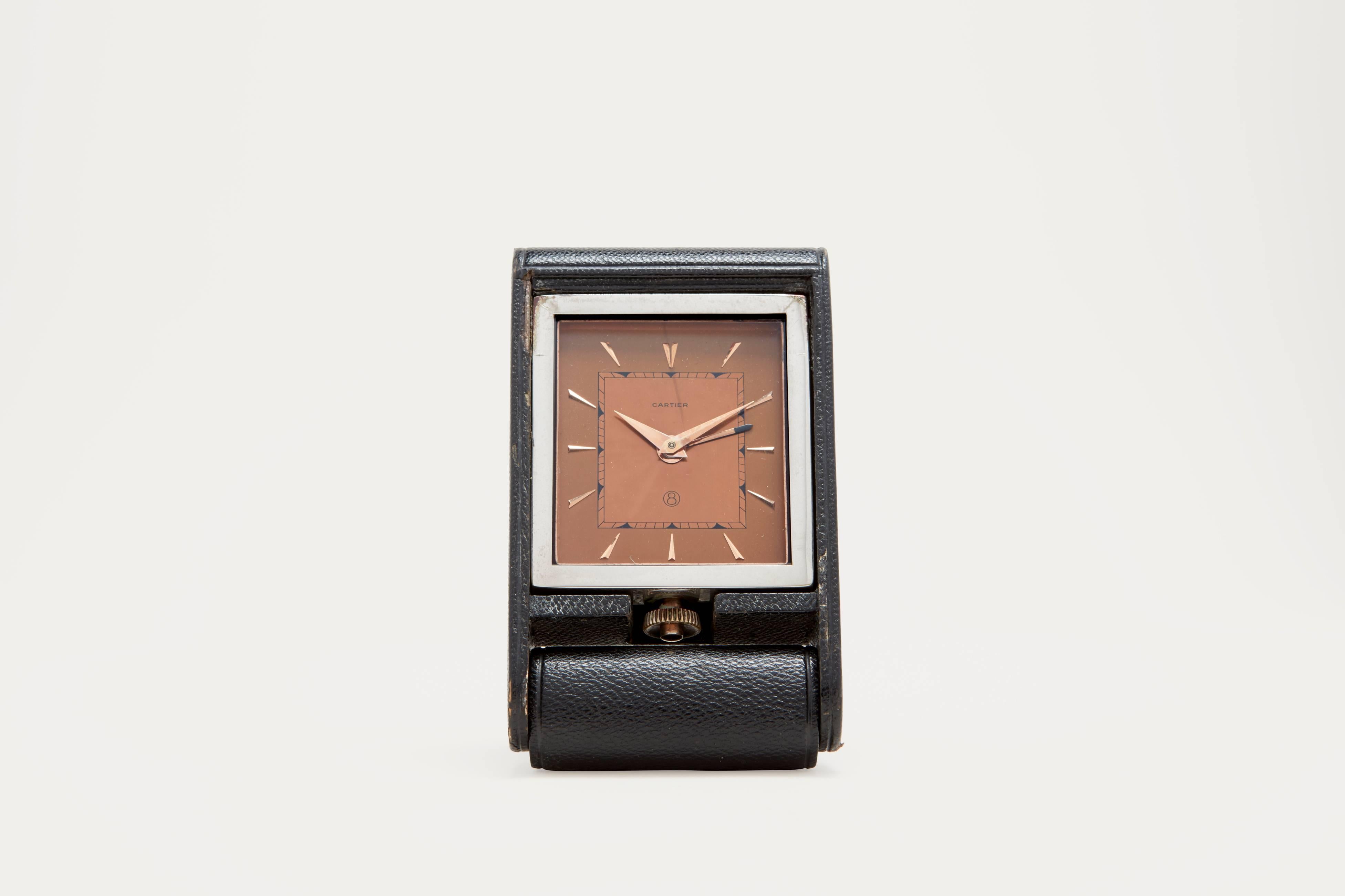 A chrome-plated and leather covered mechanical, eight day, folding, Cartier travel clock with alarm function. The clock design was originally conceived by Jaeger LeCoultre in the 1920s, and was called the 'Ados', and came in a variety of different