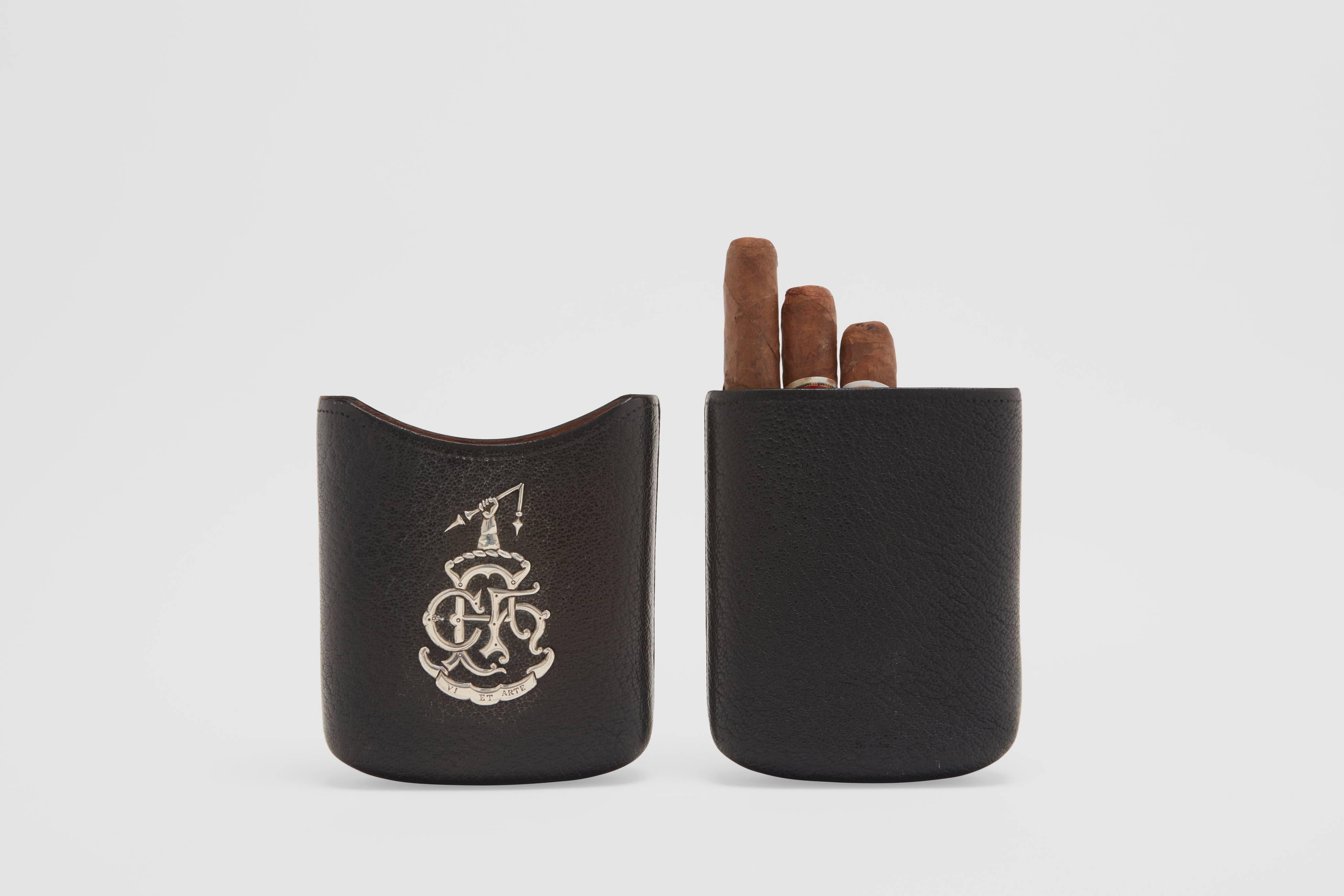 A leather and sterling silver cigar pouch.  This great looking travel pouch is set with a stunning family crest on the front.  There is a Latin inscription to the base of the crest; "Via et Arte".  This translates to "By Strength and