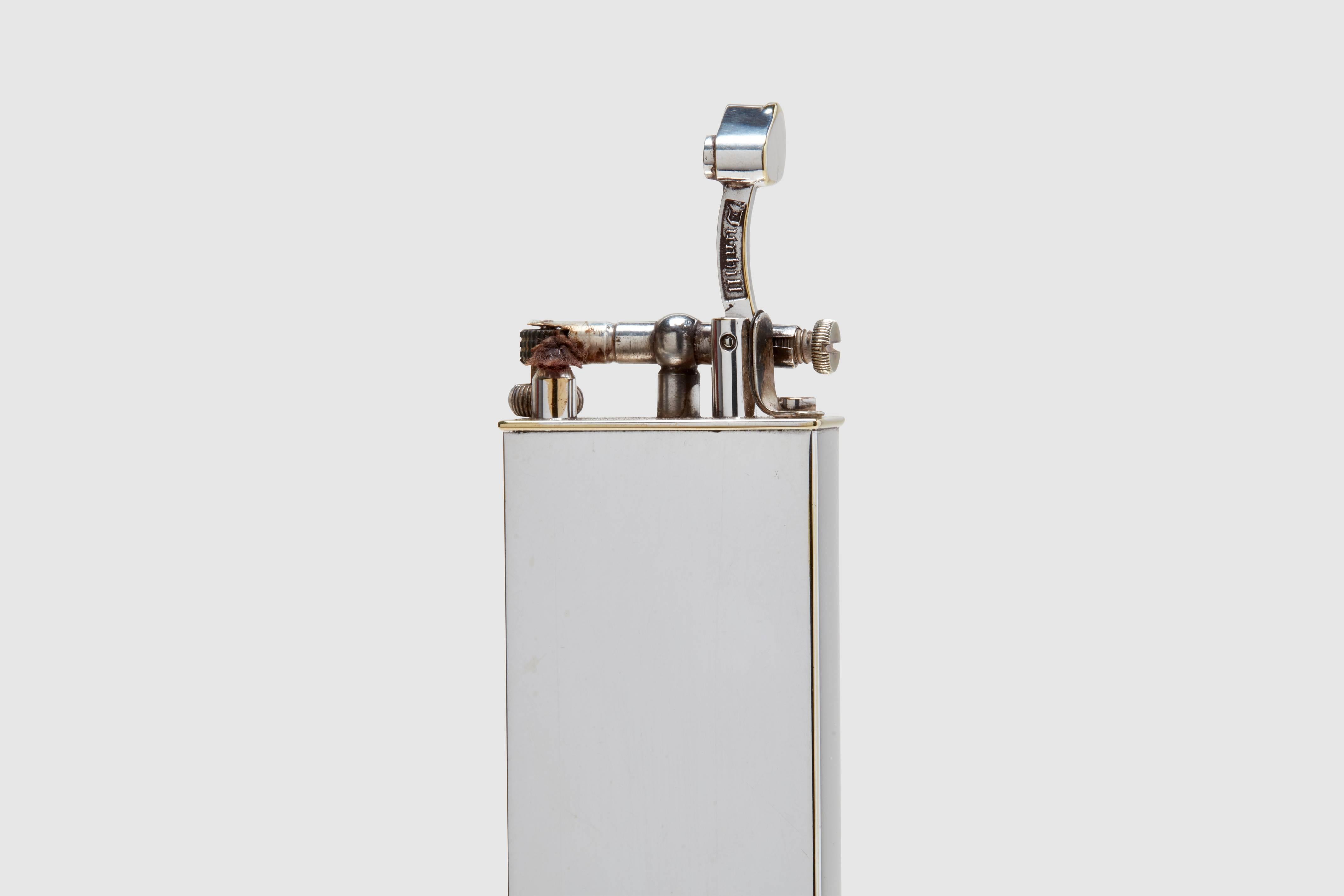 A silver plated petrol foot long table lighter.  This is a very rare piece indeed. This model is usually seen with markings as a twelve inch ruler.  This example, however, is plain with no engravings.  It is a classic form 'lift arm' lighter.  It is