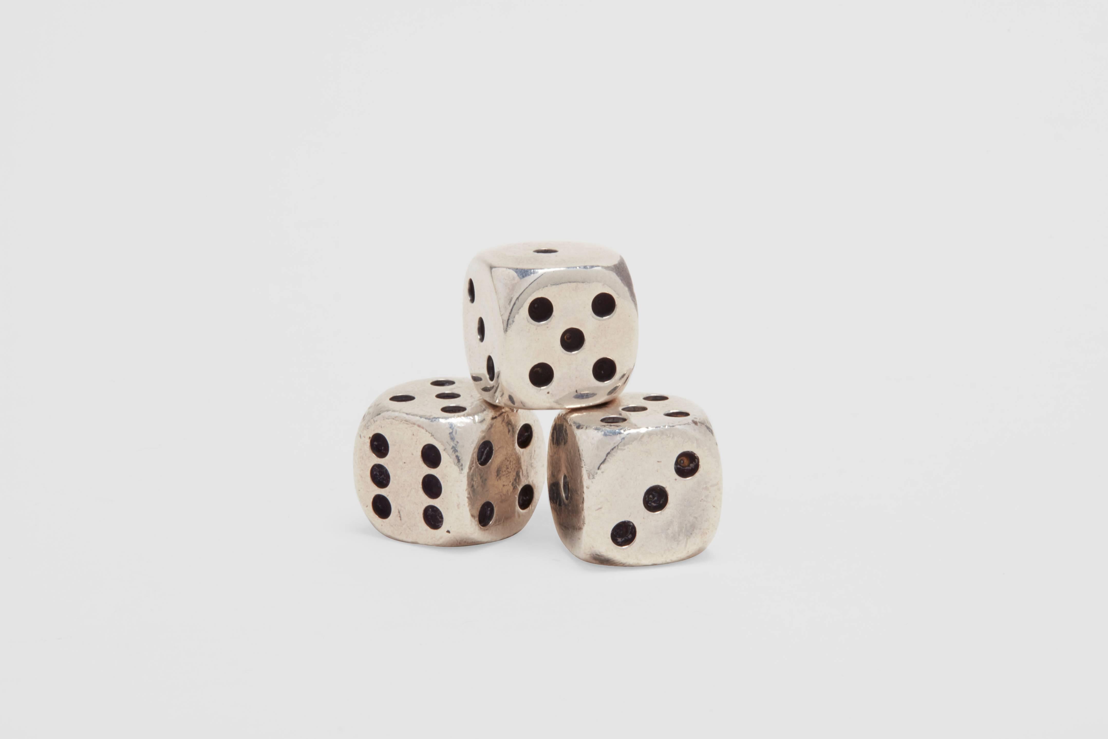 A sterling silver cup and three sterling silver dice. This wonderful set of dice is of the highest quality. The heavy sterling cup is lined with cork in order to not damage either the dice or the cup while shaking, and also to reduce the noise level