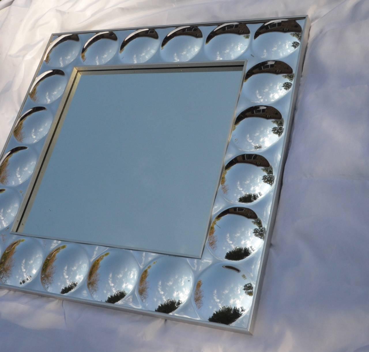 Iconic pop art mirror with raised acrylic 'bubble' frame. The mirror has a brushed aluminum frame and is heavy and well made. Made by Turner Wall Accessories it still retains the original labels on the back. Ready to hang. Measures 36