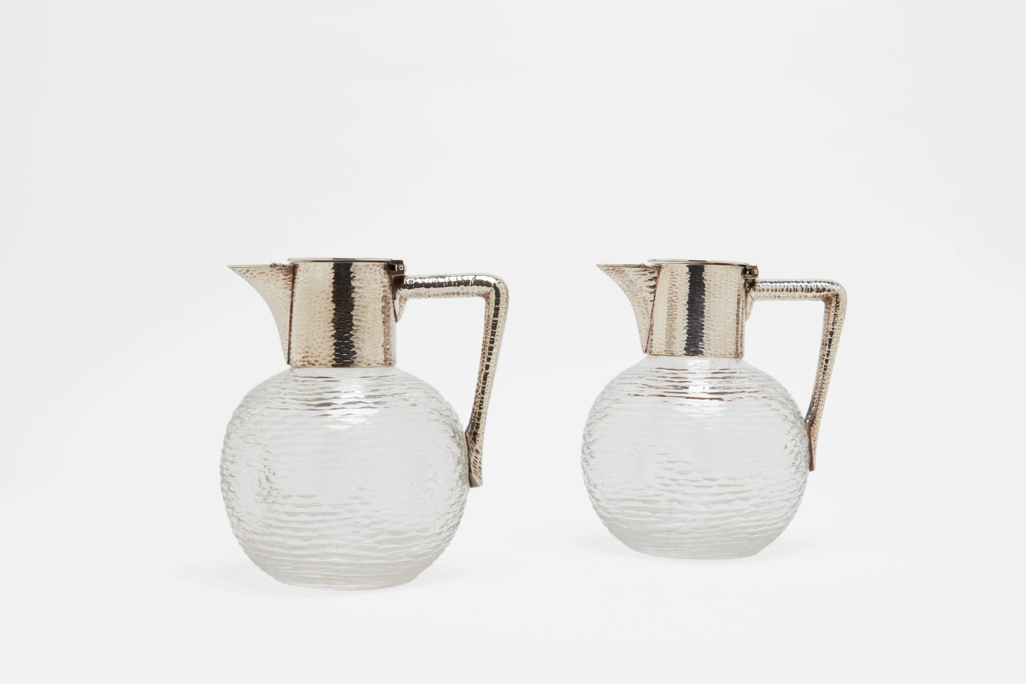 A pair of silver plate table water or wine pitchers in straw grain cut-glass and straw grain silver plate. These beautifully made and perfectly proportioned pitchers are made by one of England's great silversmithing companies, Hukin and Heath.
The