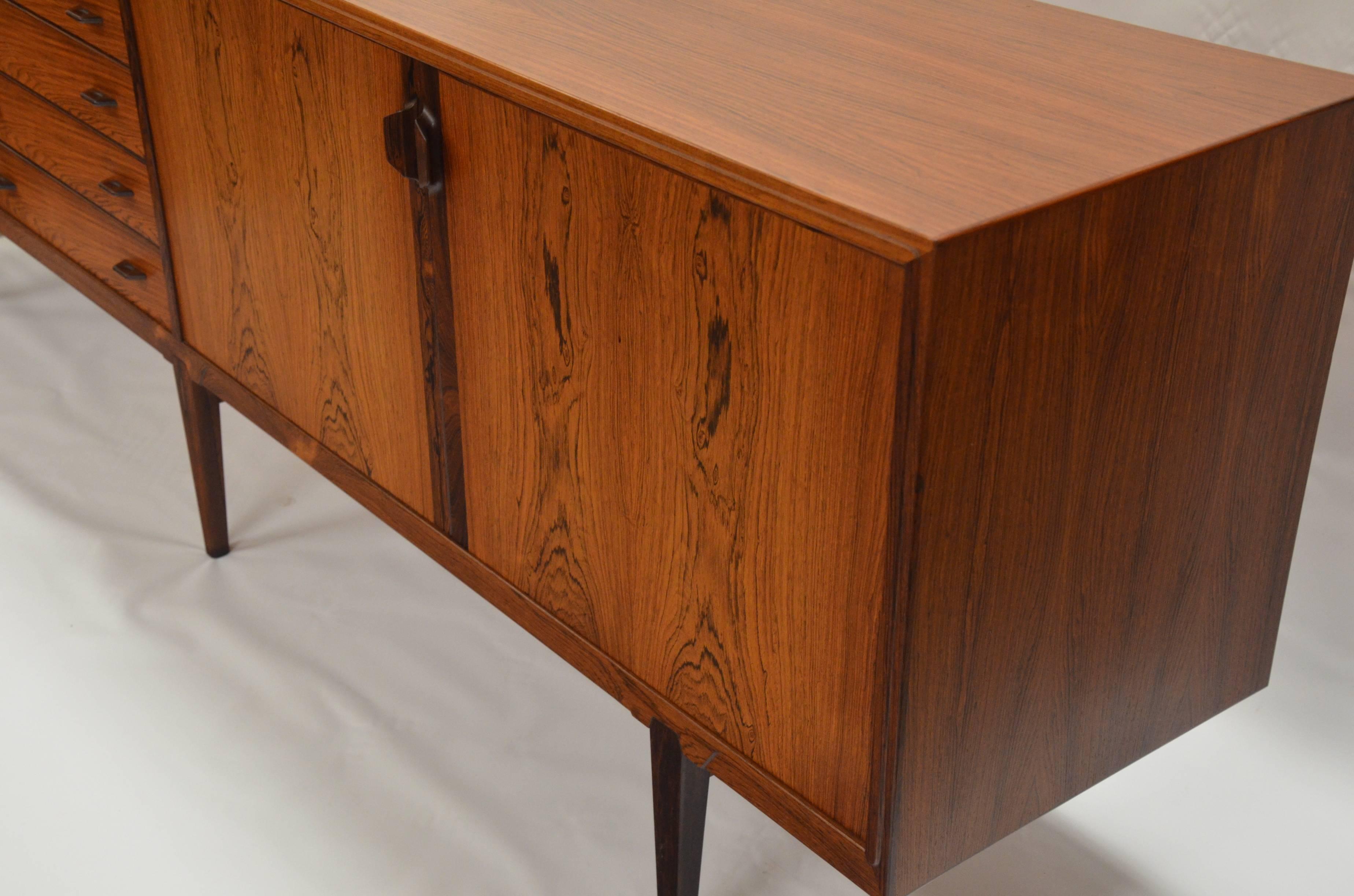A Mid-Century Danish Modern rosewood credenza designed by Henry Rosengren Hansen for Brande Møbelindustrie. Measuring over 7 feet long, this cabinet is a beautiful, high quality example of Scandinavian design. Sculpted out of rosewood, it is