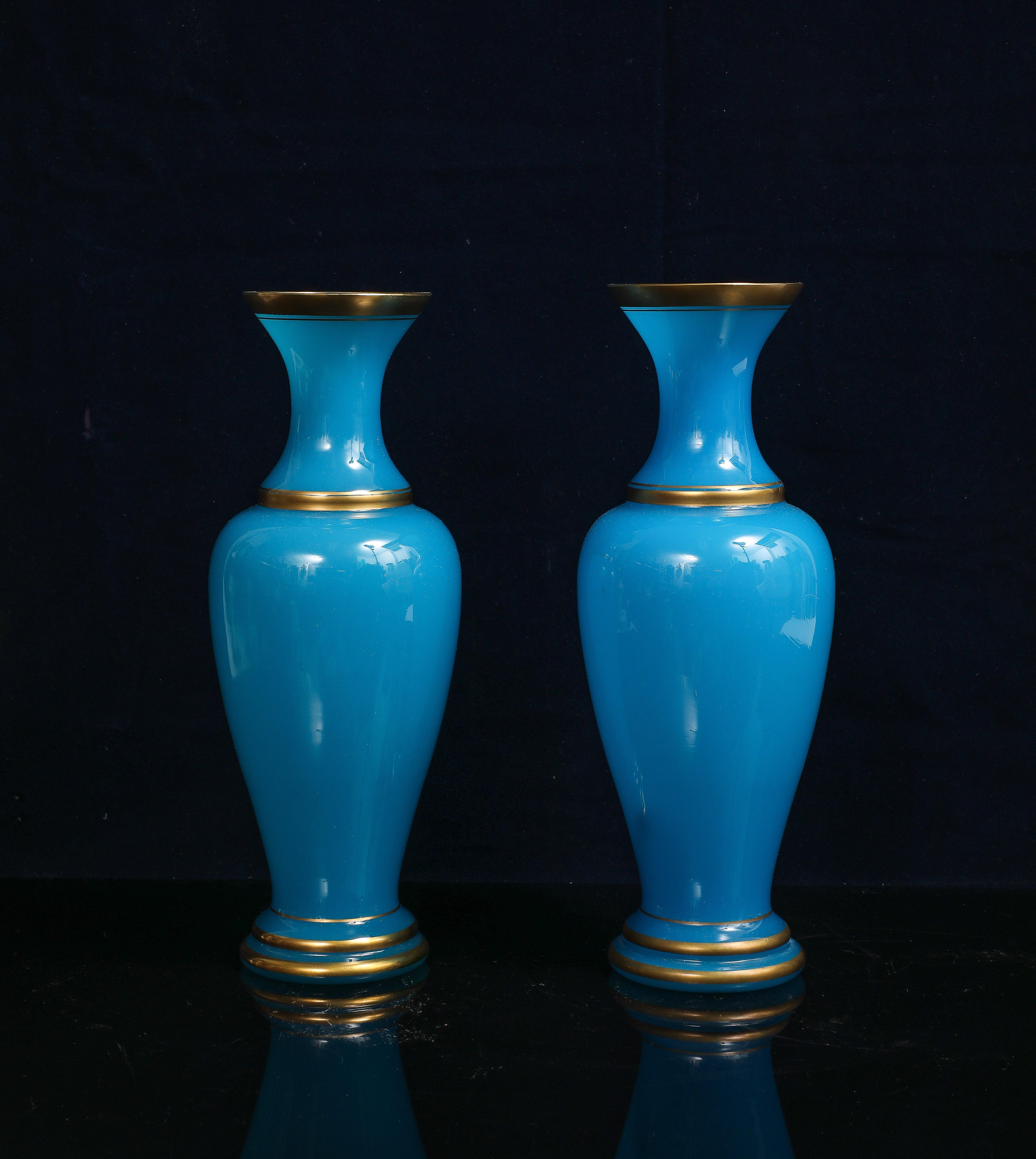 Coppia di vasi in cristallo opalino blu francese con accenti dorati attribuiti a Baccarat.   Questa coppia di vasi è stata prodotta molto probabilmente dalla manifattura Baccarat in Francia ed è composta da cristallo opalino blu con accenti dorati.