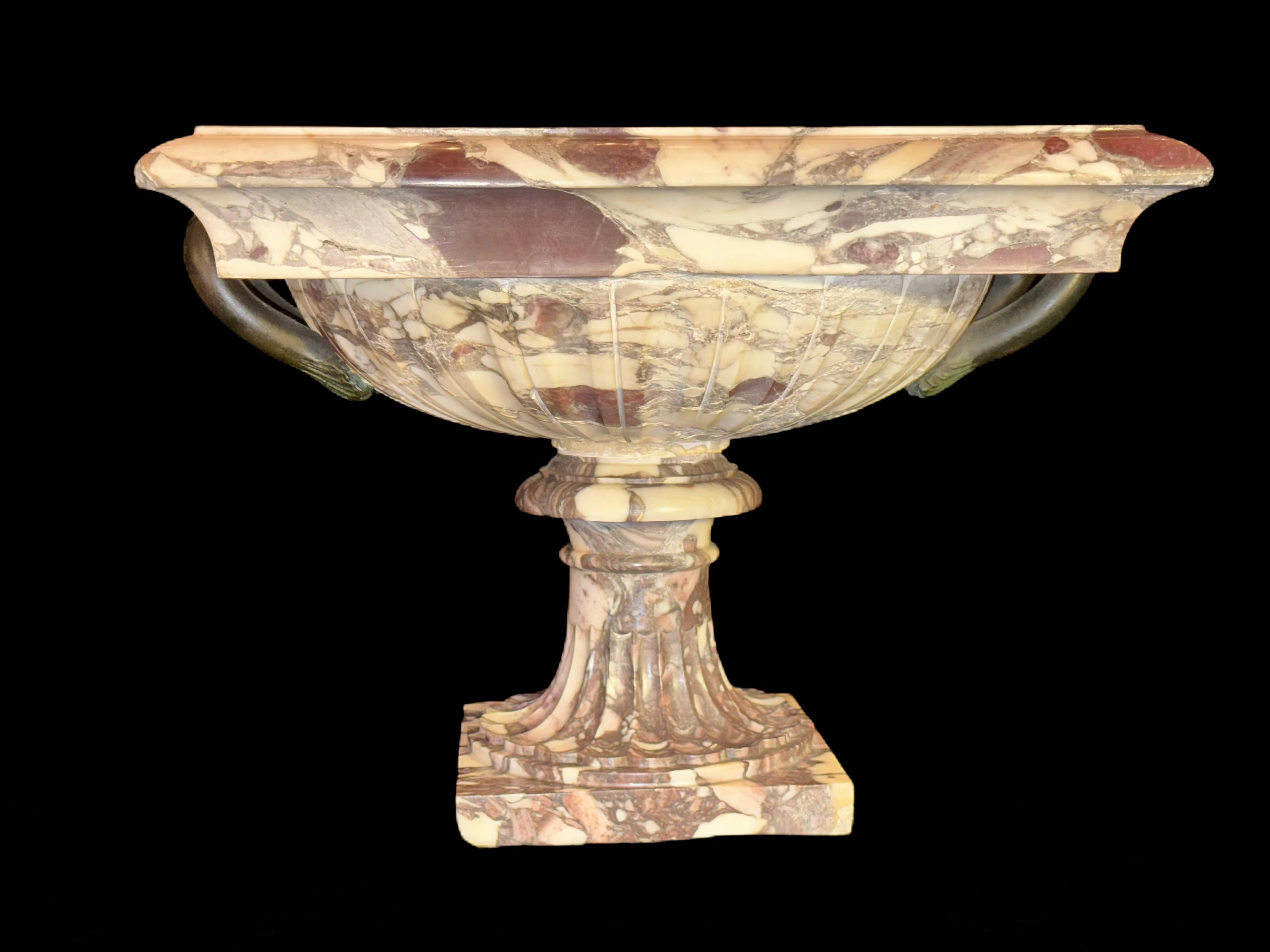 Magnifique centre de table italien du XIXe siècle, sculpté à la main et à double poignée en bronze, avec corps cannelé. Le bol est taillé dans un seul morceau de brèche, caractérisé par un motif varié de veines crème, bordeaux et grises.