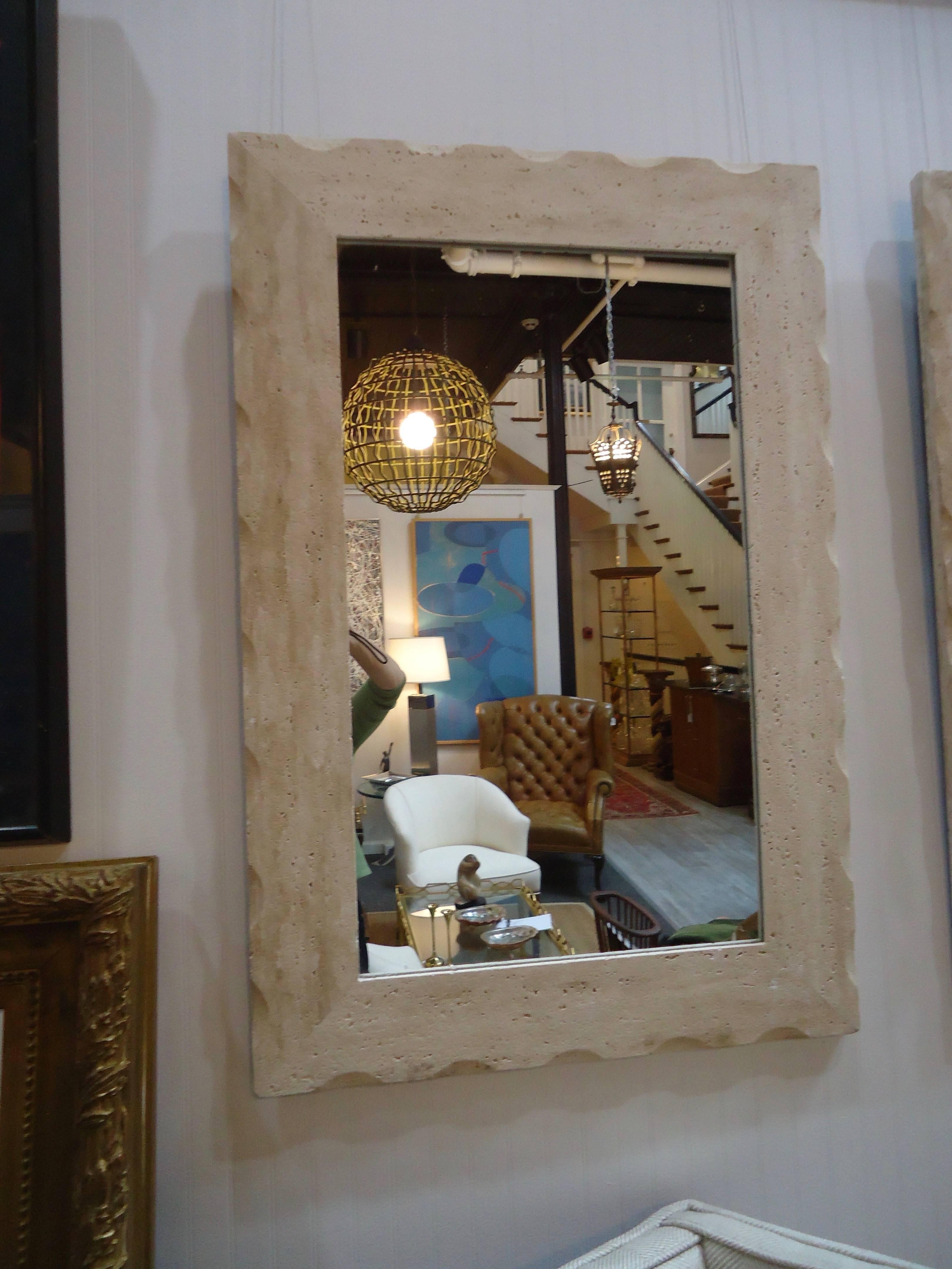 Two contemporary style mirrors having neutral cream travertine frames with subtle scalloping around the edges. Can be hung horizontally or vertically.