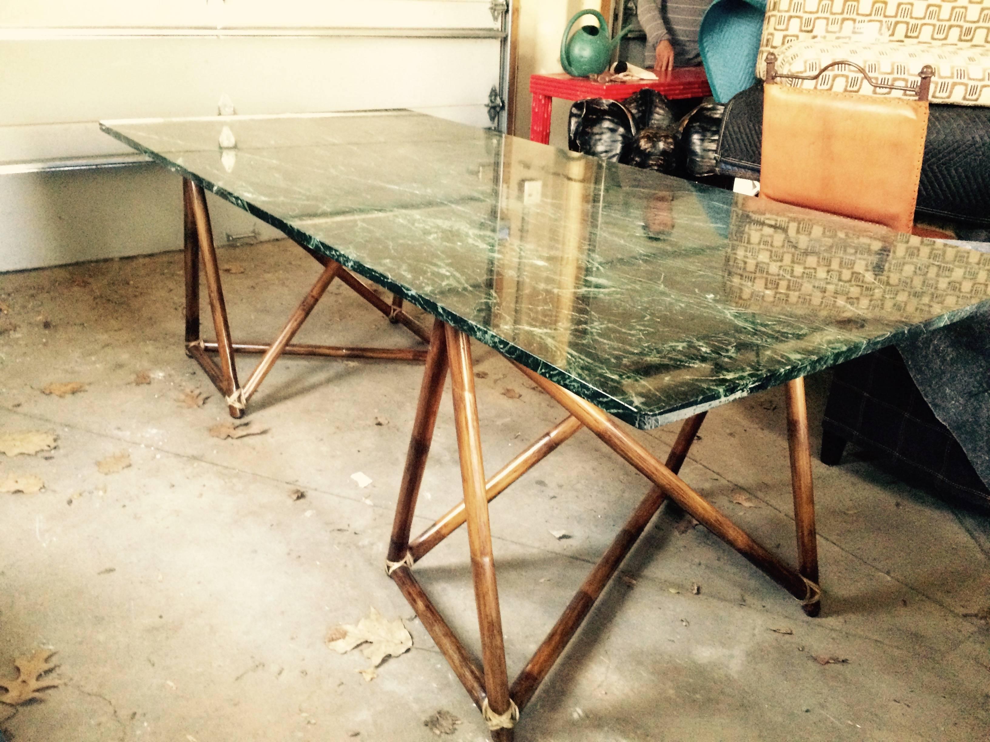 Beautiful slab of rectangular marble in rich forest green with spectacular veining and handsome wooden legs wrapped in rattan. Can be used as a dining table or large desk.
 
