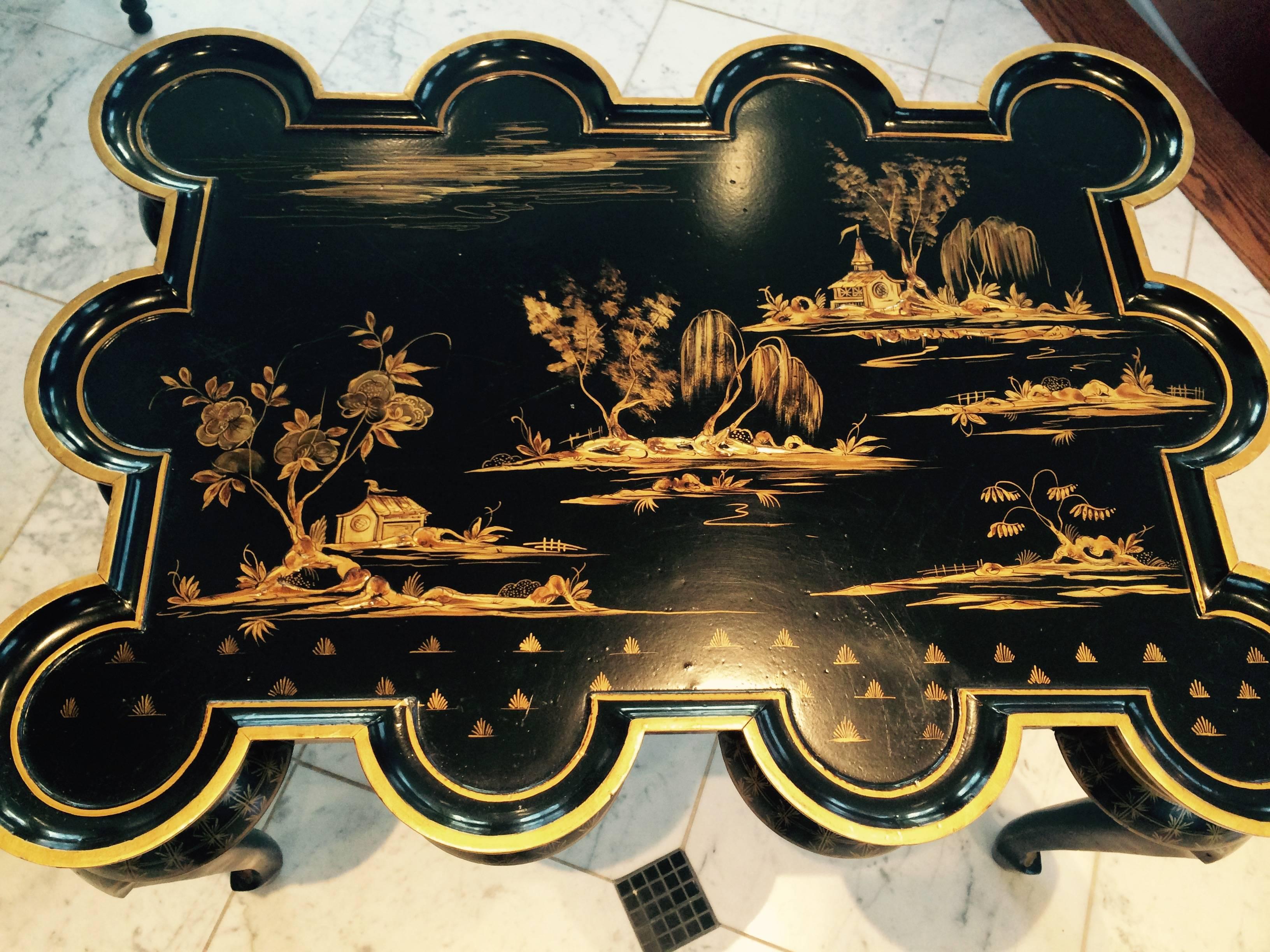 Chinese export style black lacquer coffee table having gilt with japanned chinoiserie decoration and a lovely scalloped shape.