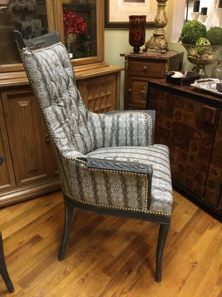 Pair of Hollywood Regency chairs with painted graphite mahogany and re-upholstered in black and white faux snake-skin having tufted backs and carved arms and legs. Finished with silver nailheads.