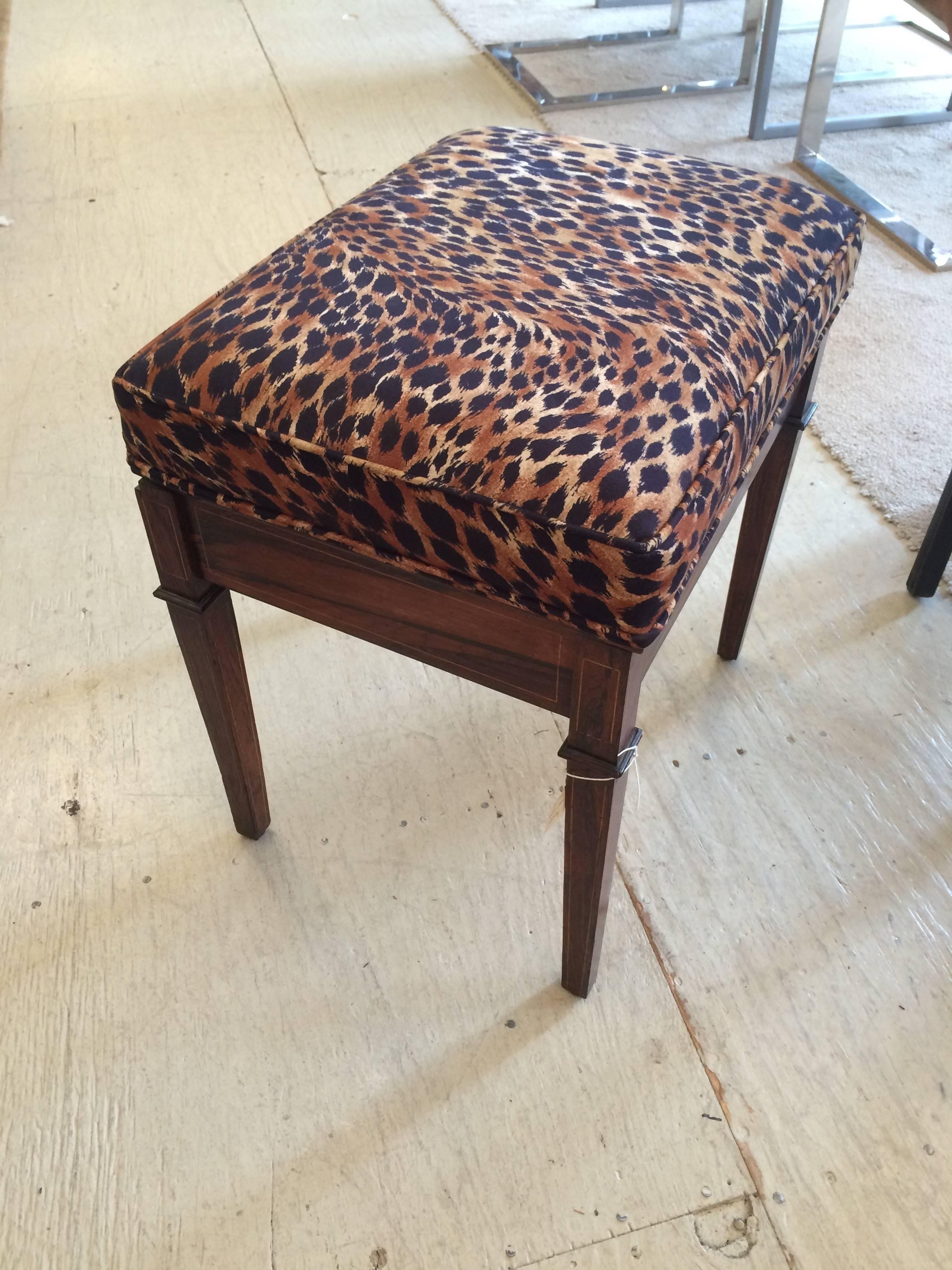 Lovely mahogany base with pretty Greek urn and curlicue decoration, having a newly upholstered designer faux suede animal print top that lifts up for storage within.

NF