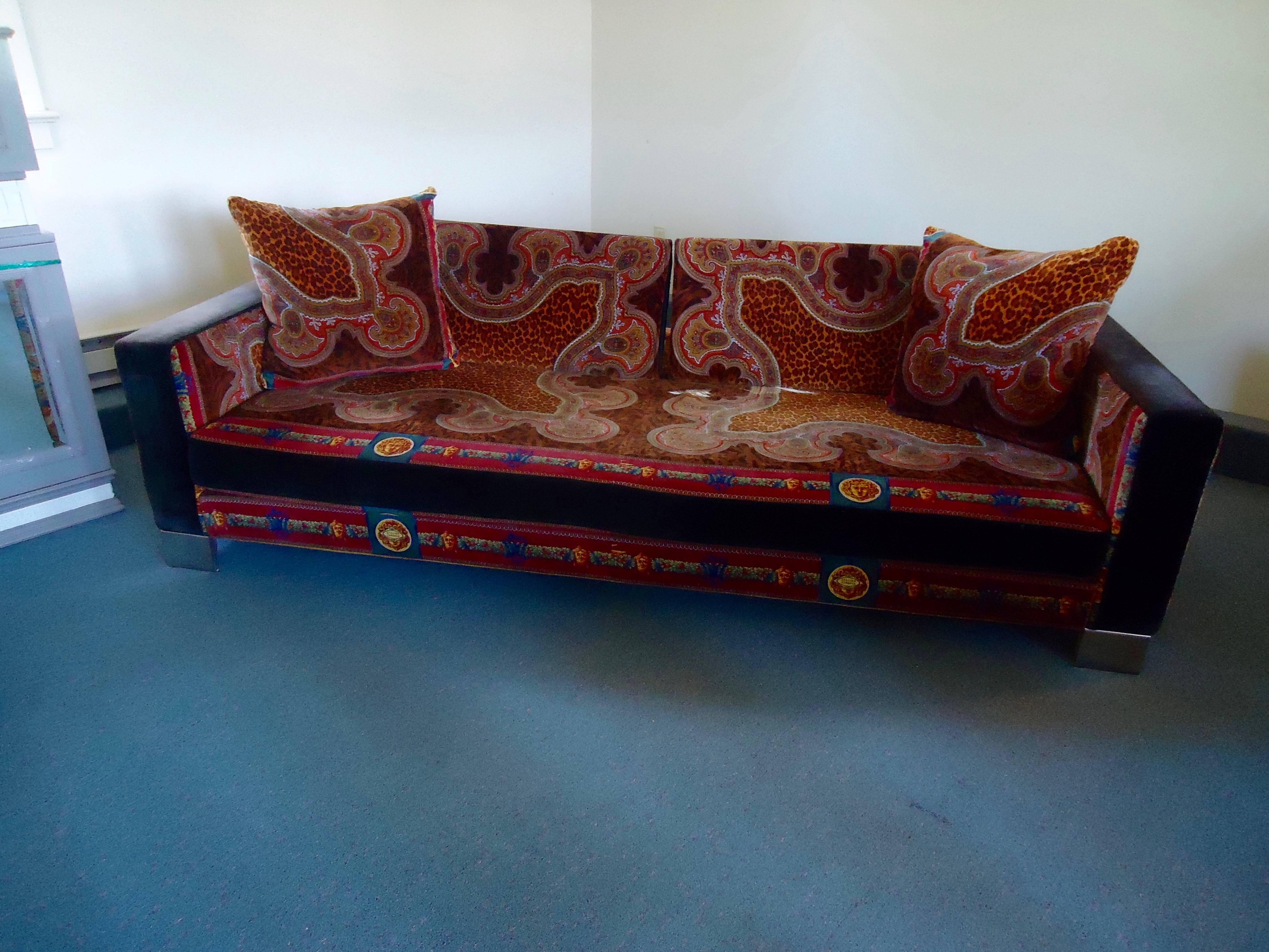A much loved spectacular daybed or couch from the Versace Atelier showroom in NYC, bought about 35 years ago in NYC. Covered in a sumptuous riot of pattern and color, the two back cushions swing back and forth to allow either a comfortable twin bed,