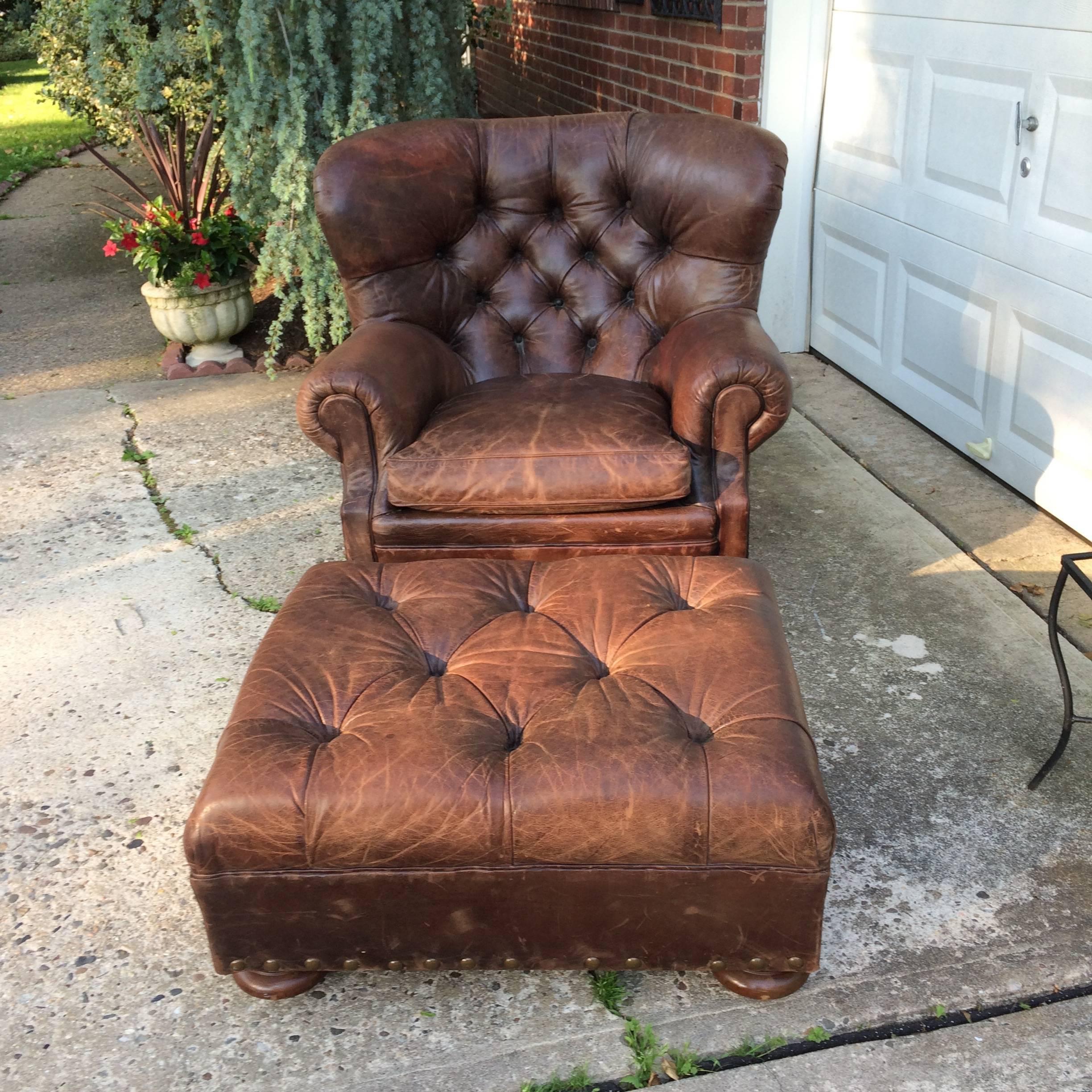 Supple brown leather big manly tufted club chair and matching ottoman with large bronze brass nailhead detailing and bun feet. Ralph Lauren label.
Ottoman is 30 W 25 D 13 H.

Seat arm 36 W.
Seat depth 26.5.