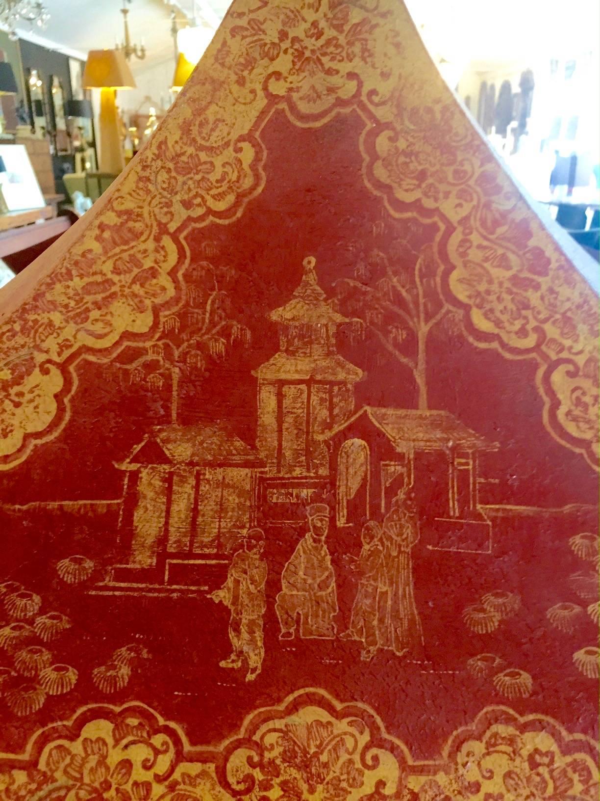 Wonderful metal cabinet to hang or sit on a table having a pagoda design with tent like top and zig zag base all painted red and gold with a chinoiserie design. Interior is painted gold and has pegs for glass shelves. These are included. Some of the