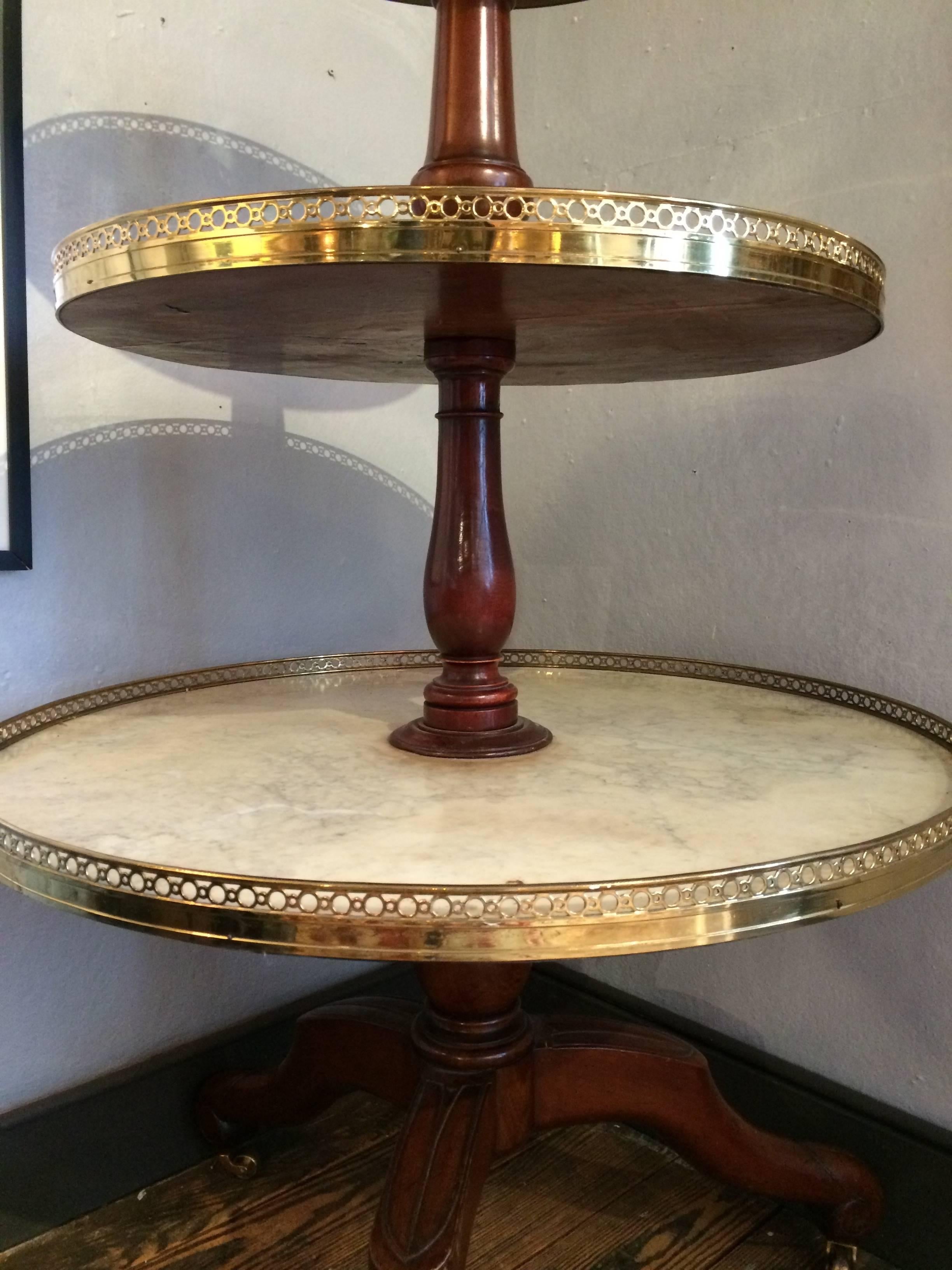 Very unusual and elegant English antique server having three-tier butler service. Each tier is a circular marble tray outlined in lovely polished brass galleries with a circle motiffe.
Bottom tray 32 diameter.
Middle tier 26 diameter.
Top 20