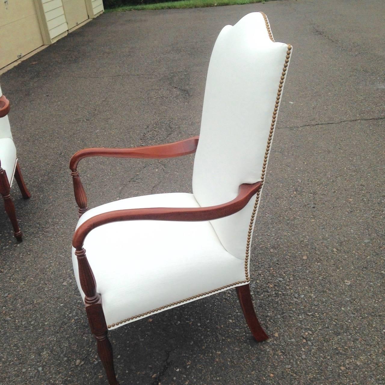 Pair of Federal style chairs without swept arms and bulbous reeded front legs,
newly upholstered in white linen with brass tack trim. Wood is probably maple stained to appear a rich mahogany color. Very comfortable.
Seat height is