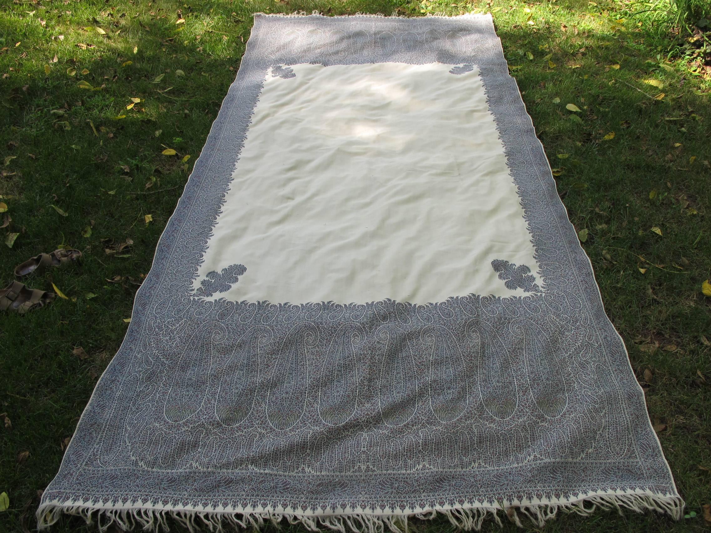 A hand loomed wool paisley long style shawl with unusual blue and cream coloration.
Very good condition with some slight scattered holes in the center portion.
 