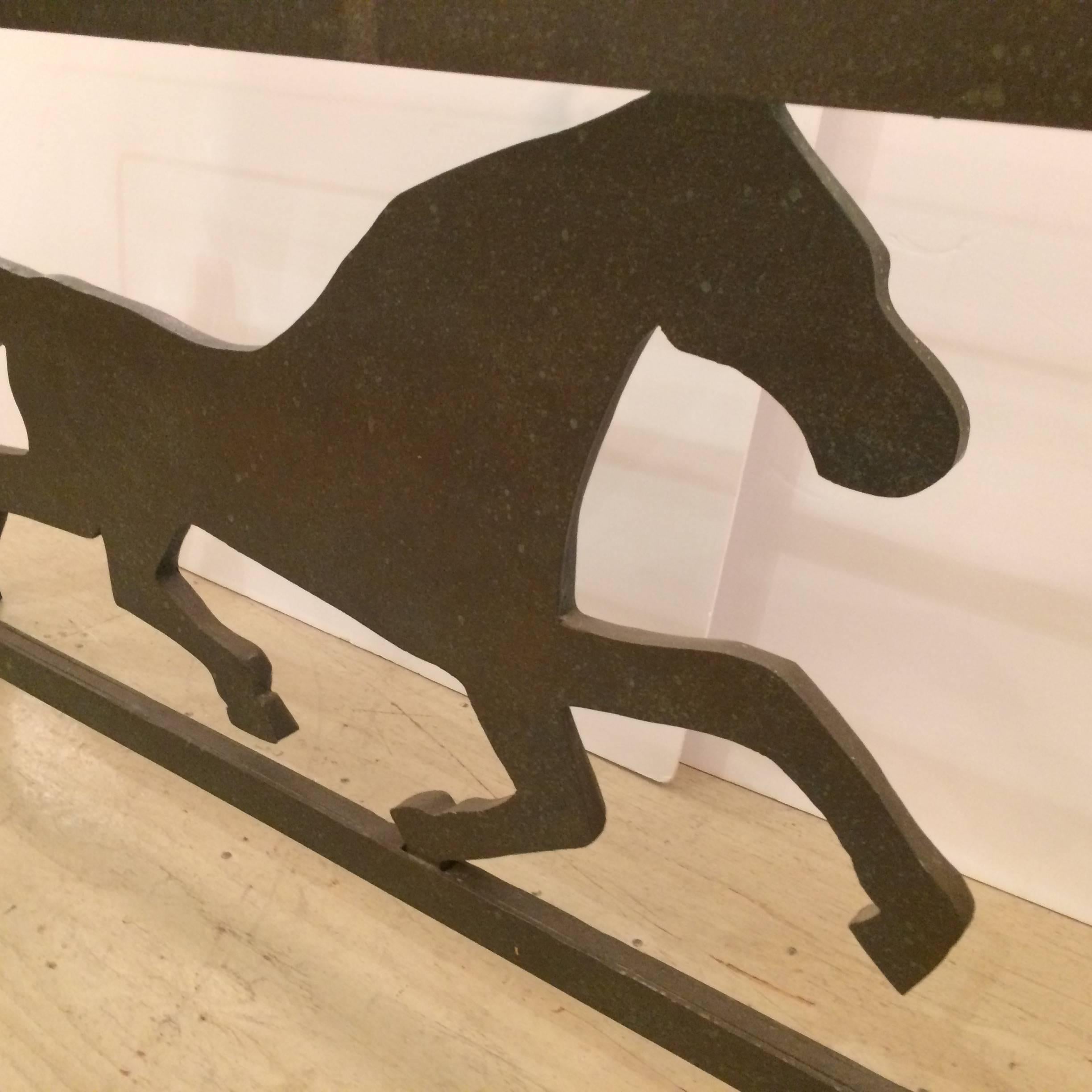Great looking three dimensional console table having a heavy brown iron base with striking striding horse underneath, heavy thick beveled glass on top.