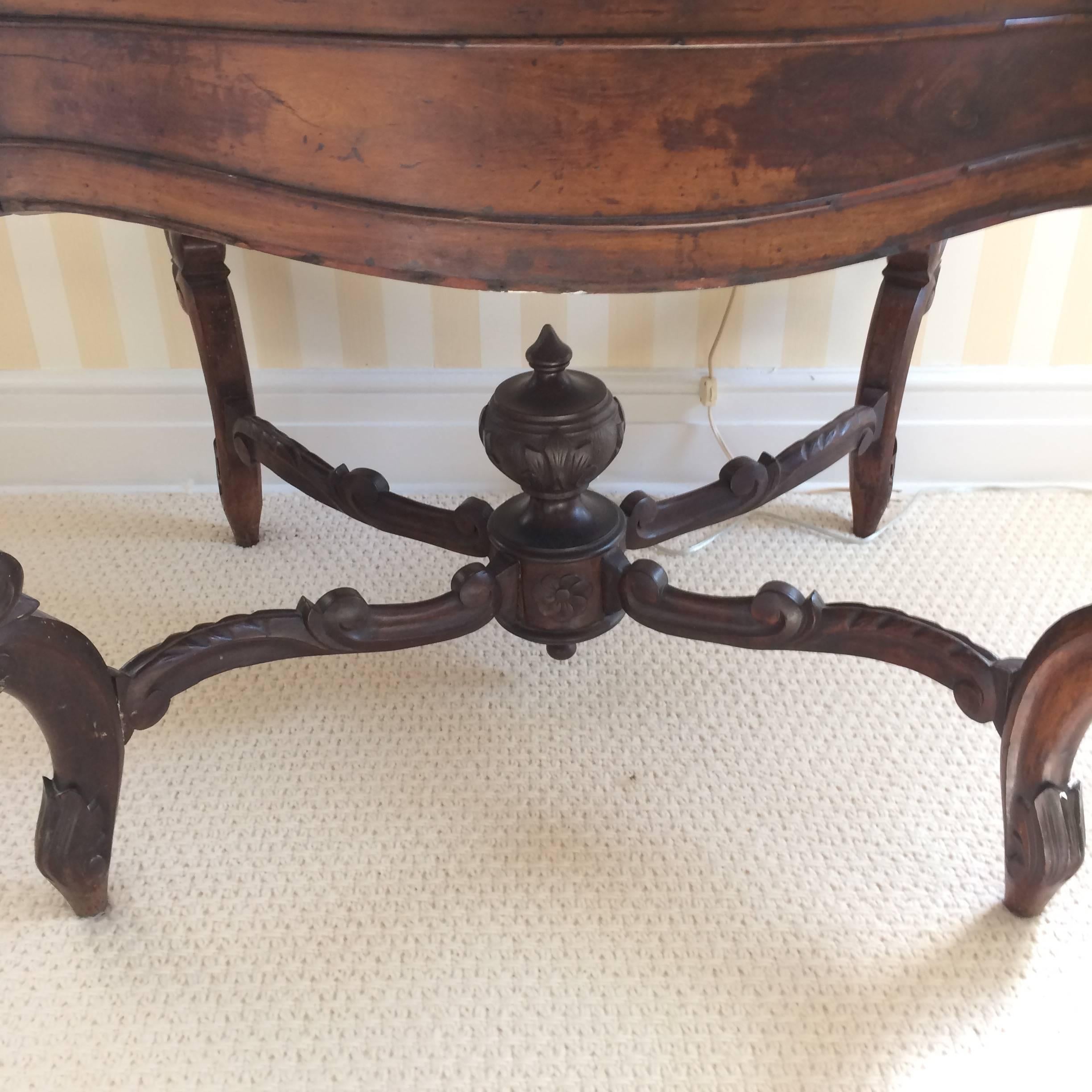 Romantic Victorian center or side table, 1860-1870, walnut, cabriole legs with a cyma curved X-stretcher and lovely central finial. The white marble top is turtle back shaped.