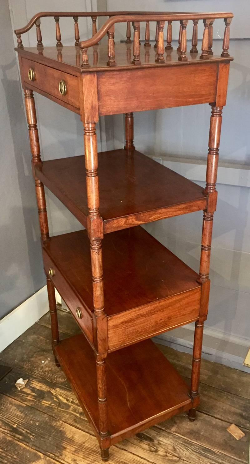 Elegant English mahogany etagere having four tiers, two drawers with original hardware and a lovely wooden gallery around the top.