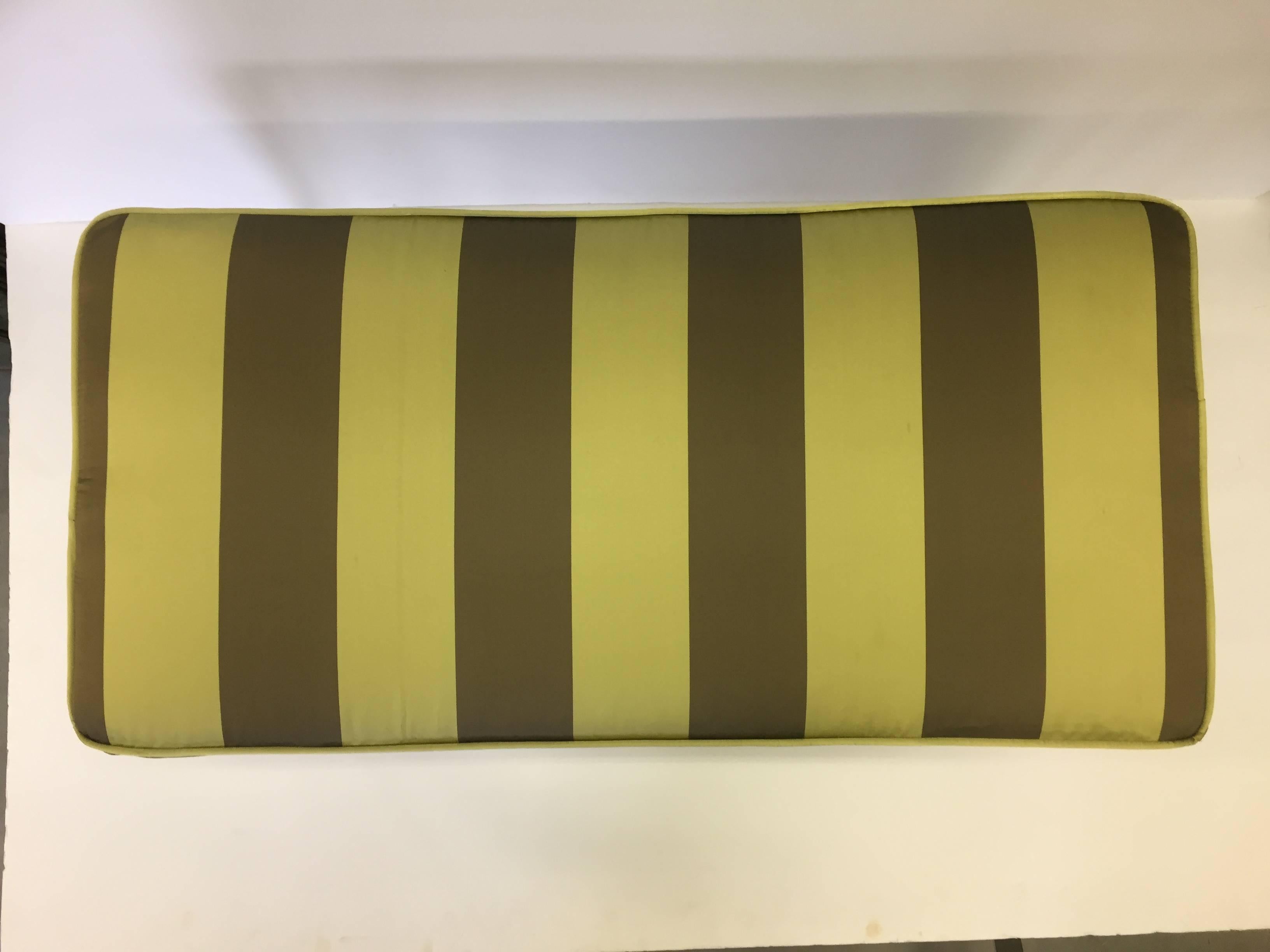 Absolutely gorgeous bronze bench with detailed Egyptian motif having figural women at the top of each curvaceous leg with intricate feet at the bottoms, newly upholstered in an elegant chartreuse green striped silk.
