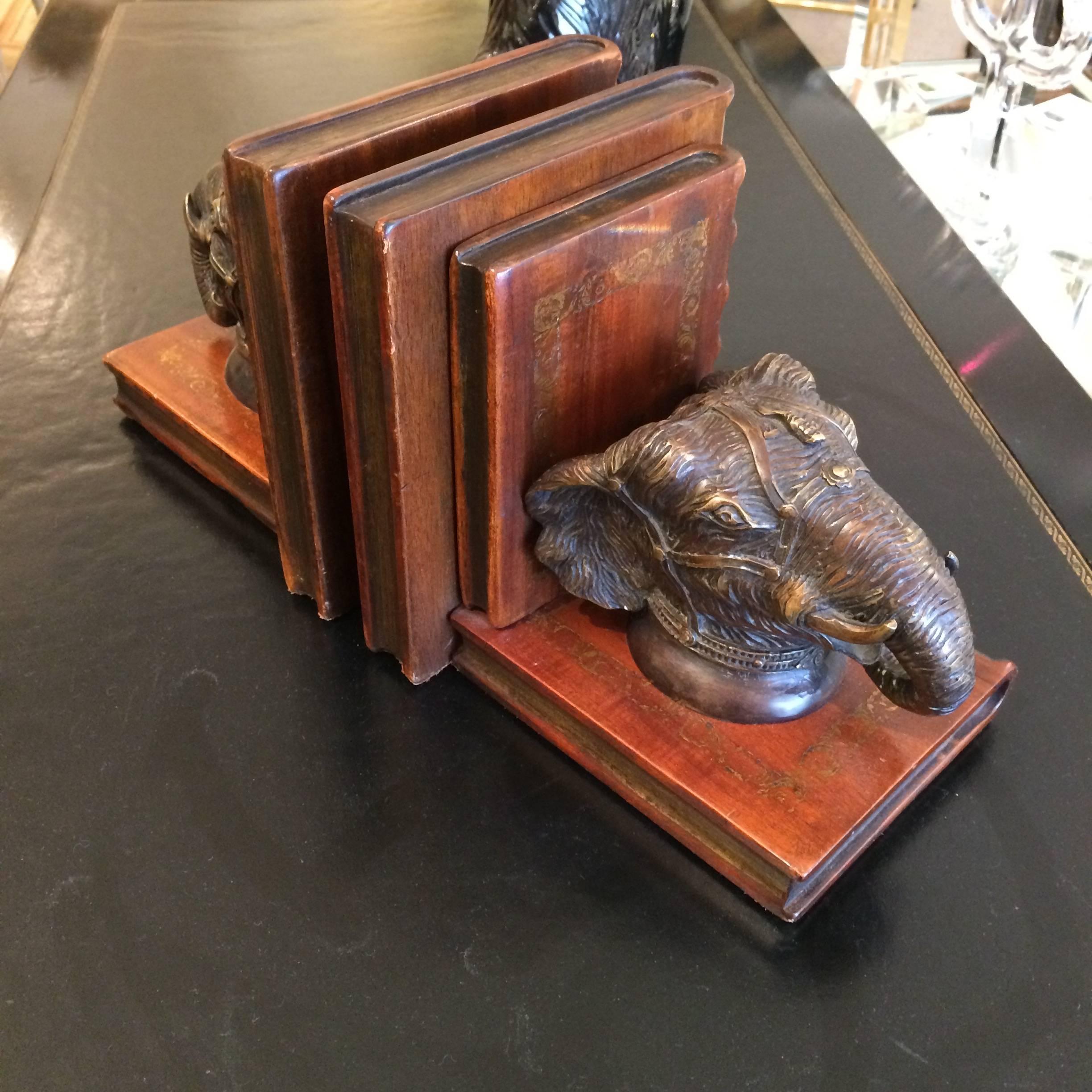 Very handsome bookends with rich patina by Maitland Smith, having carved wood books that look like leather, bronze elephant heads, and embellished subtle gilding.