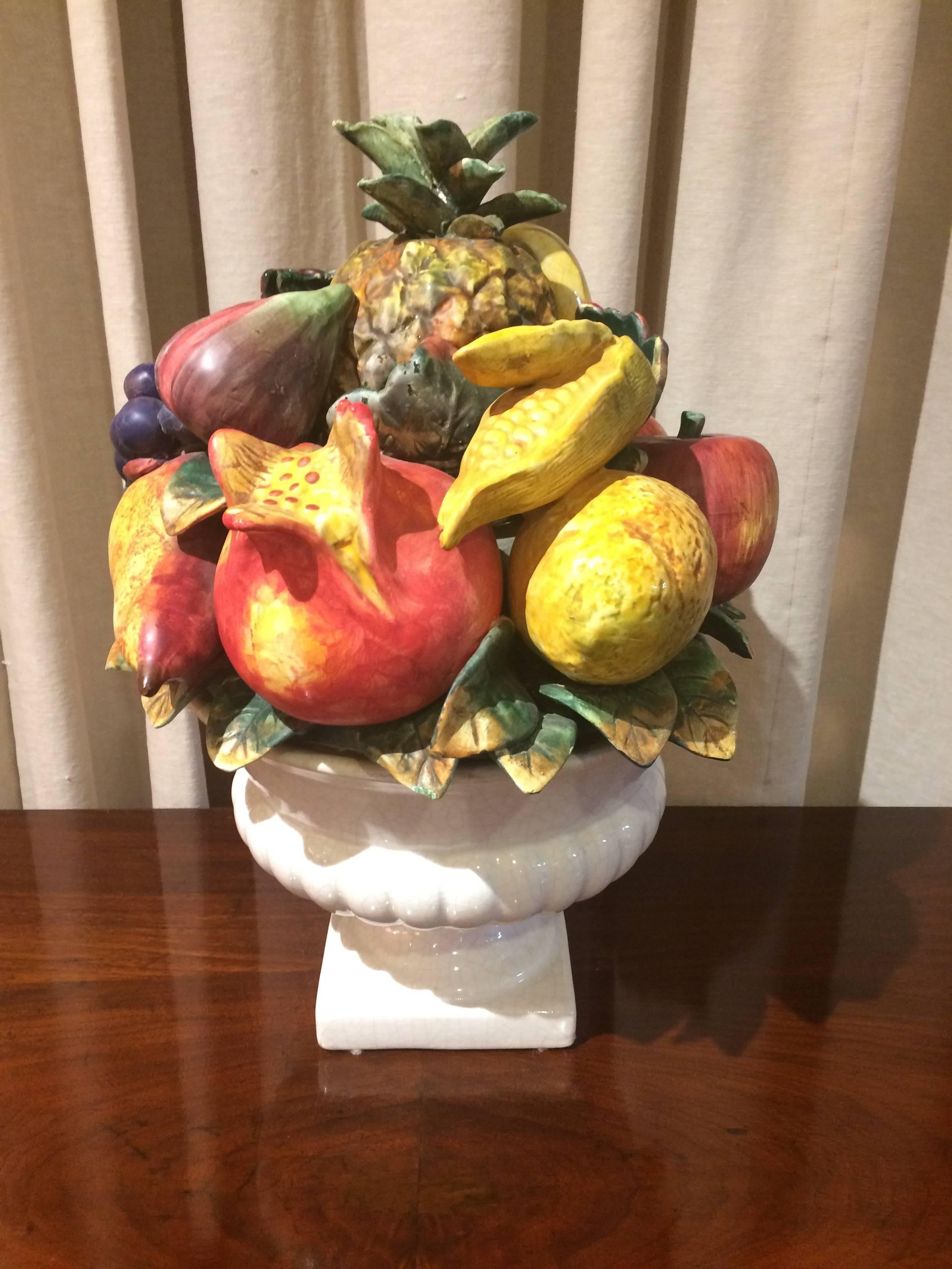 Wonderful sculptural centerpiece having a white ribbed ceramic bowl overflowing with an artful arrangement of luscious fruit including pineapple, pomegranate, grapes, figs, bananas and more.