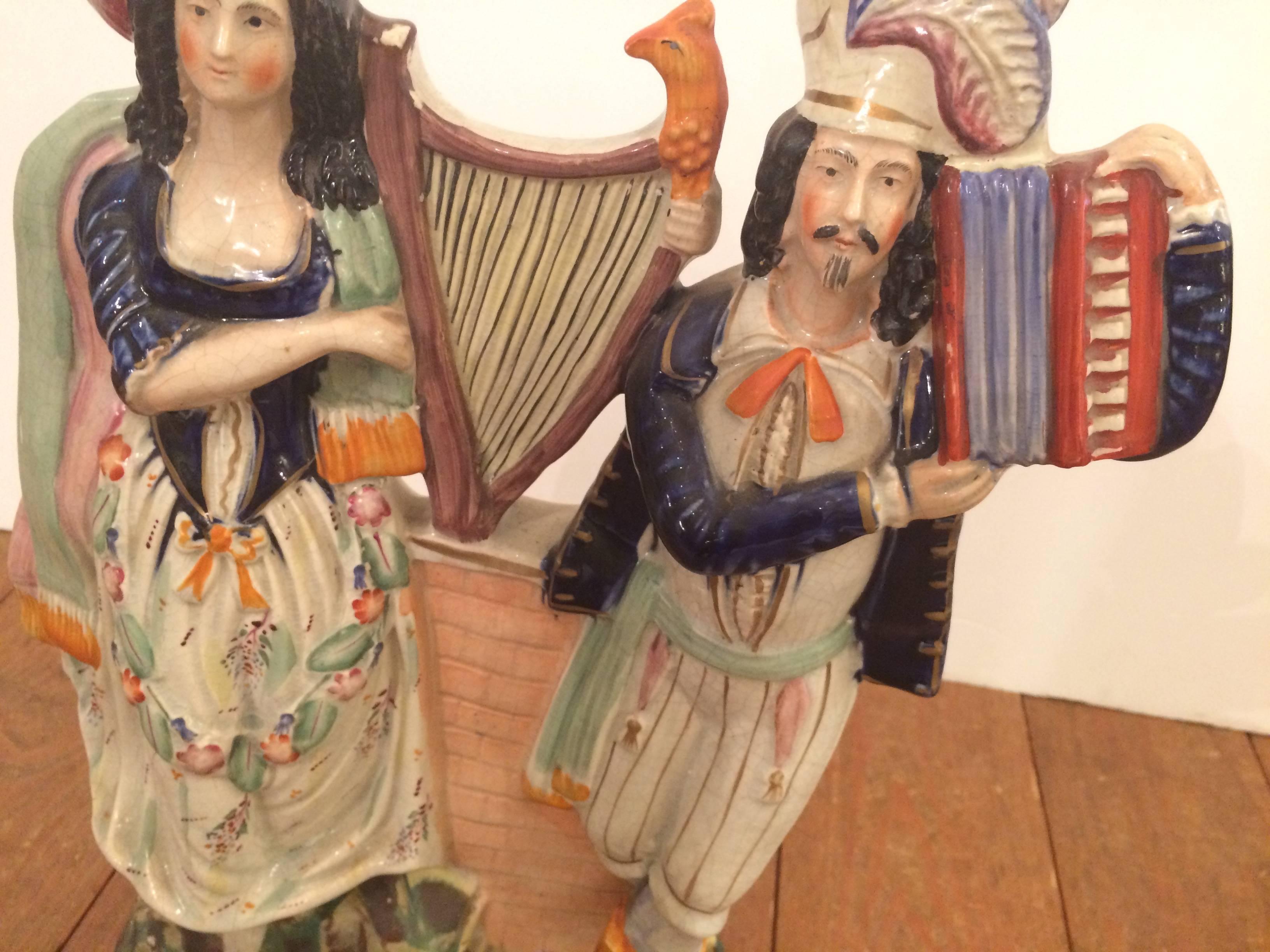 Wonderful Staffordshire sculpture of a man and woman playing musical instruments.