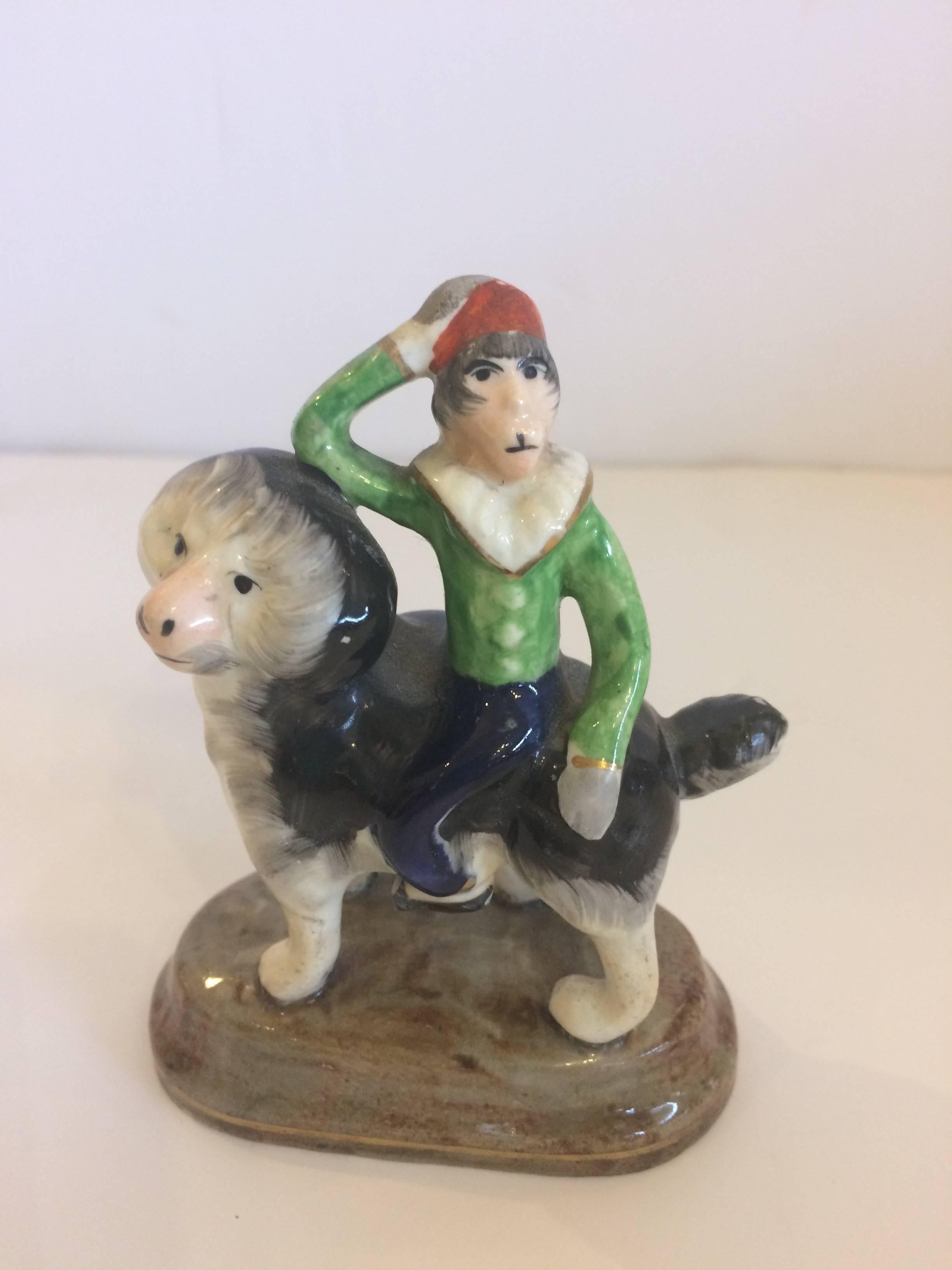 Diminutive Staffordshire having a darling monkey riding on the back of a fluffy dog.