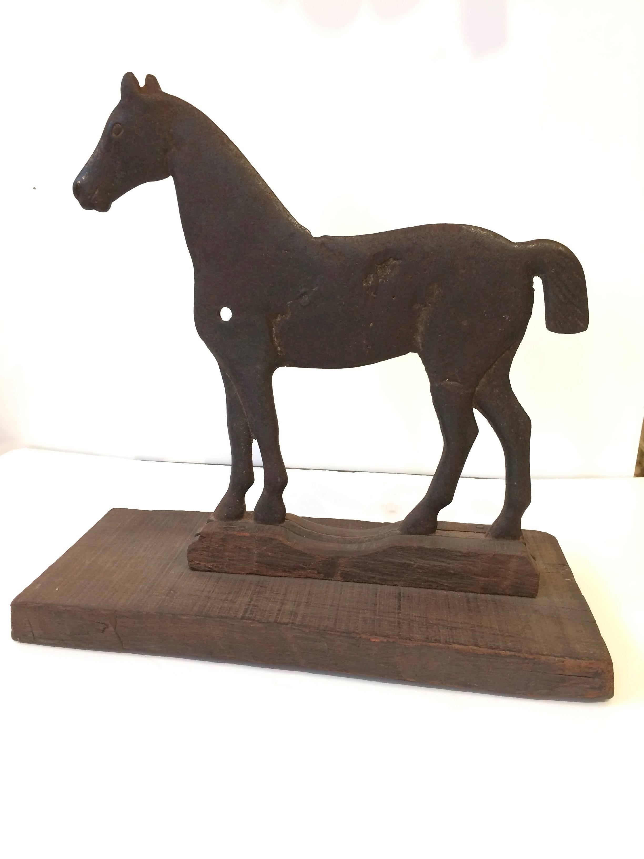Wonderful found object bobtail horse made of weathered cast iron, once a windmill weight from Maine, mounted on barn wood base to be a fabulous tabletop accessory. Dempster Nebraska Manufacturing, circa 1880.