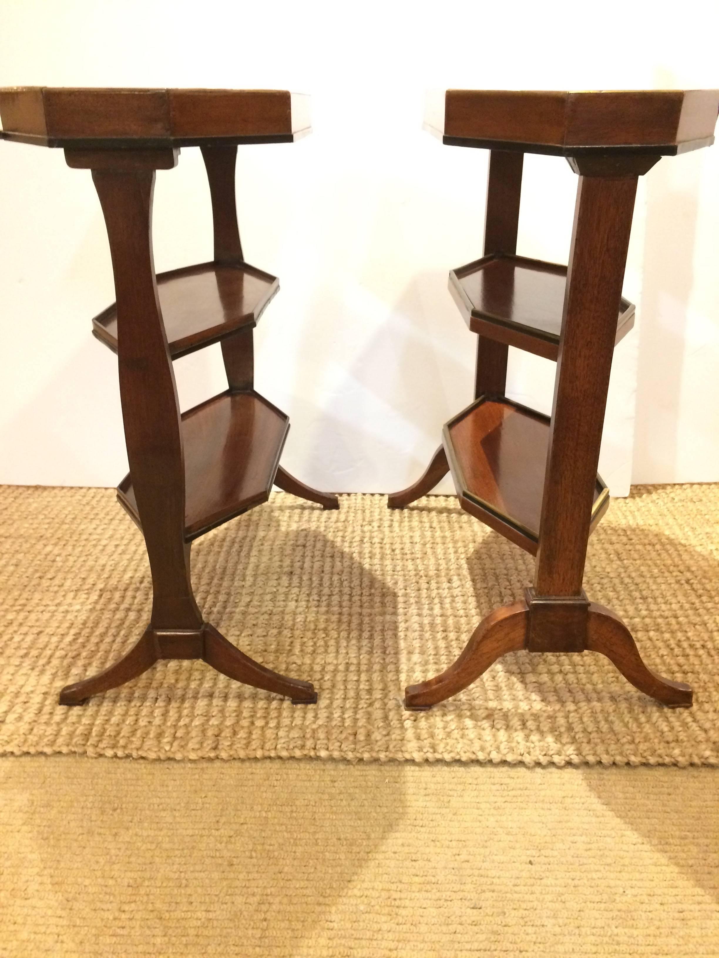 Rare and valuable pair of three-tier mahogany octagonal shaped etagere style tricoteuses. Adding to their interest is that they are not an exact match, with subtle differences in the shape of the sides and feet. One side table has brass and ebony