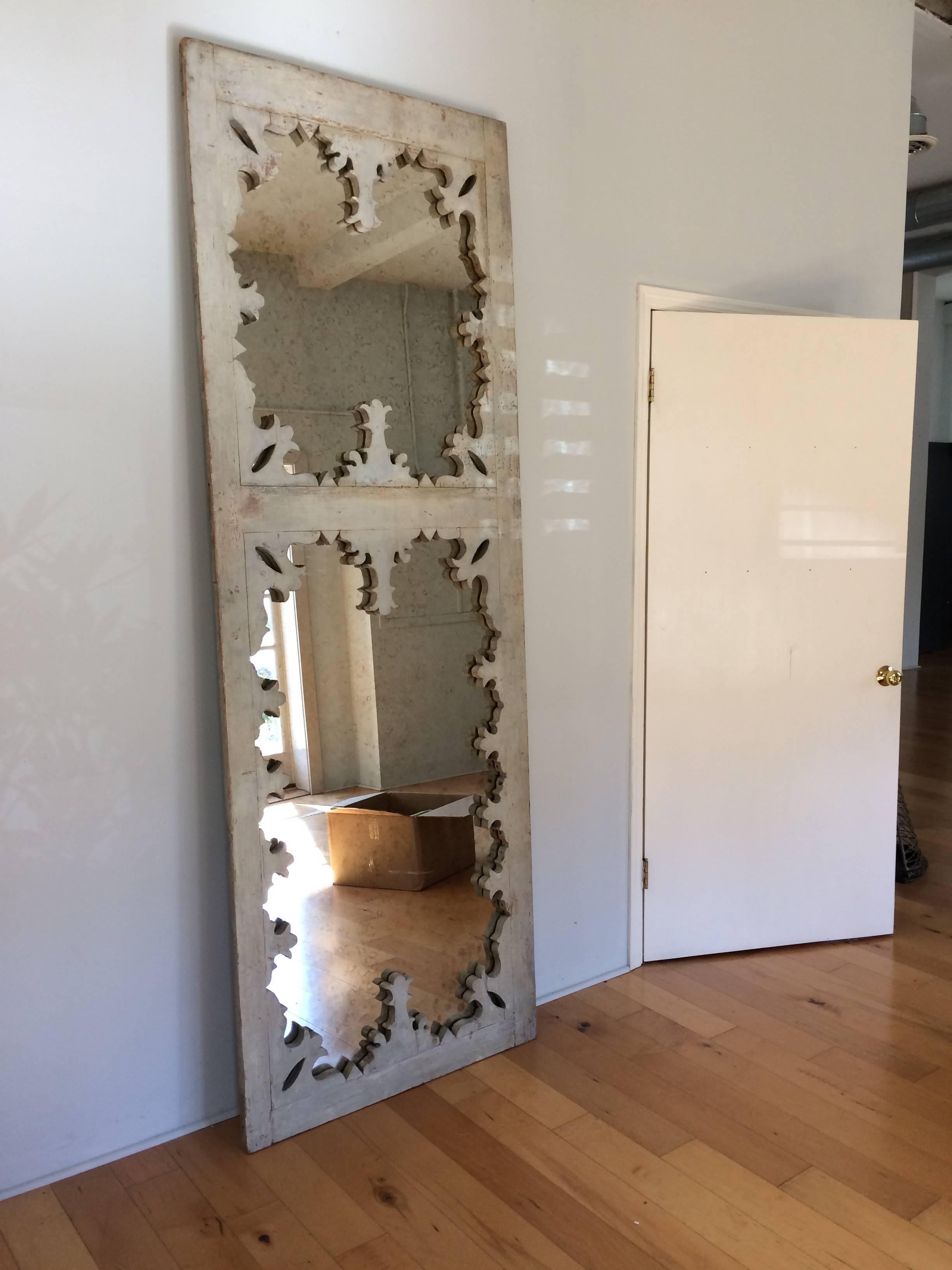 Wonderful super tall Victorian door with original paint and distressed patina, fabulous decorative cut-out edges and newly filled with antiqued mirror.