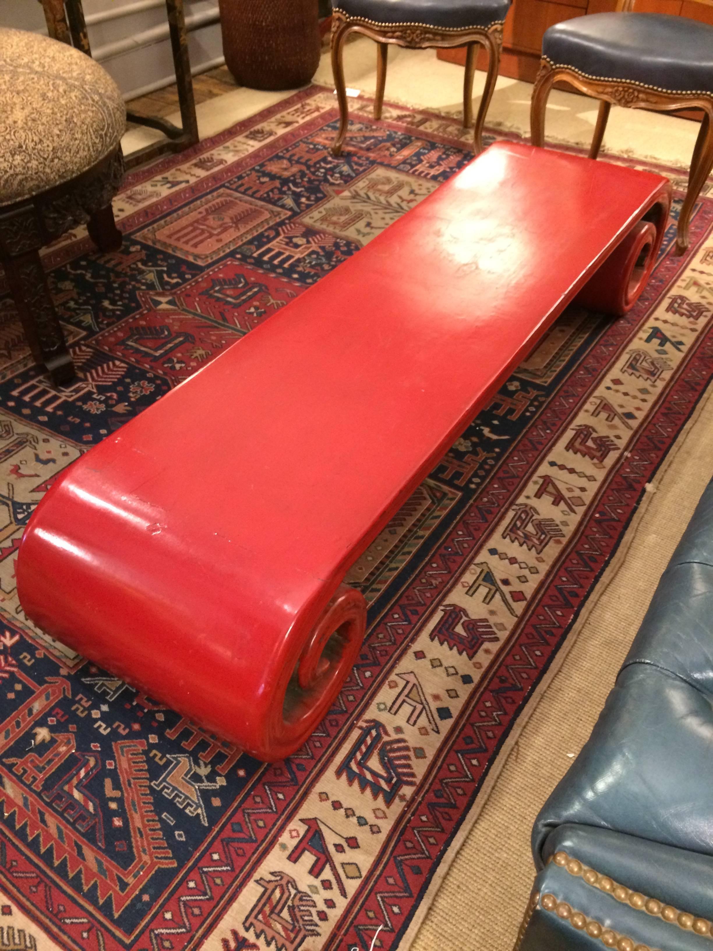 Rare coffee table with a scroll curlicue shape, painted wood in a bright tomato red. Low to the ground and sensually sculptural.