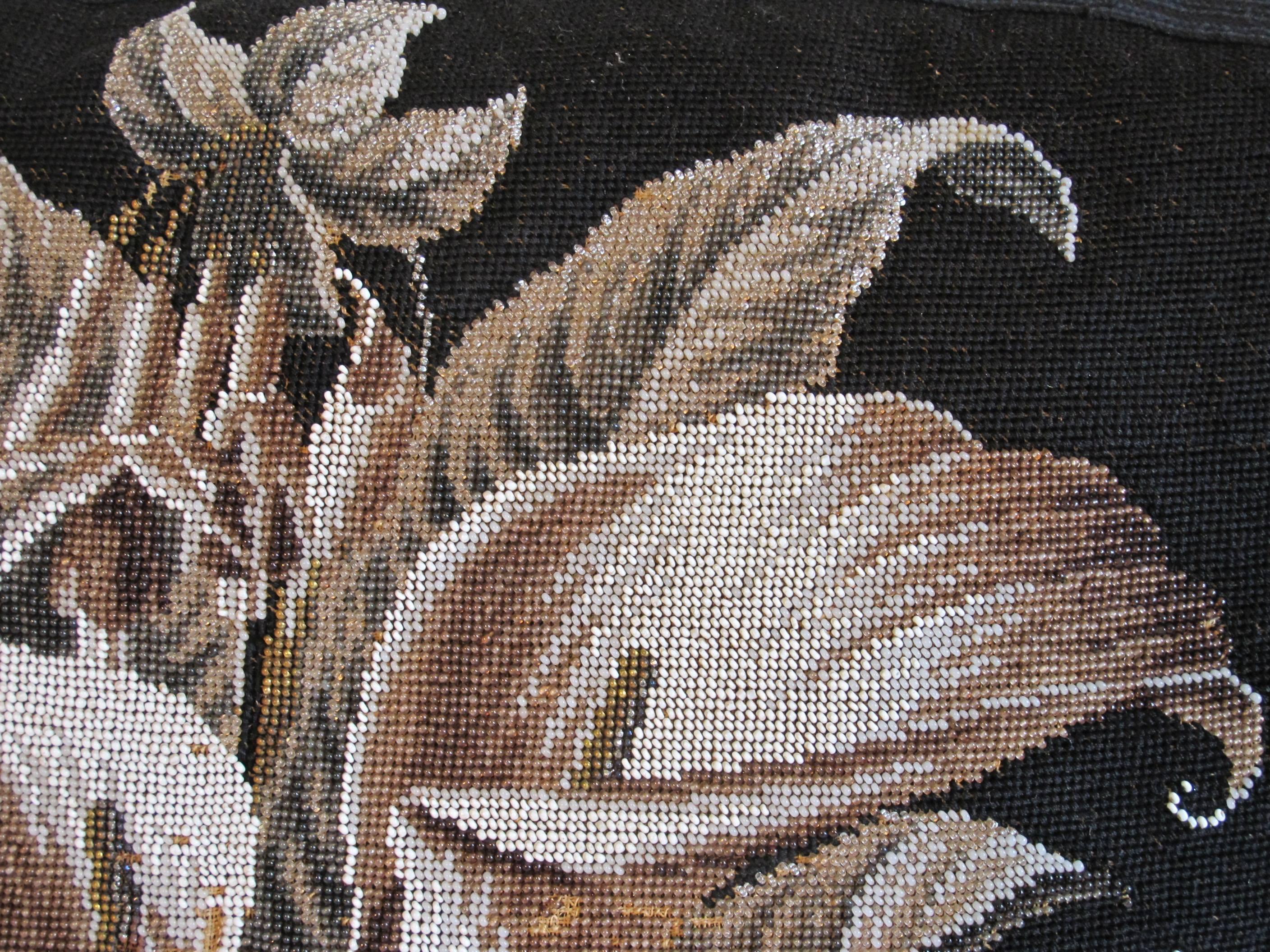 An early Berlin work beaded needlepoint pillow, depicting a glorious bouquet of lilies in shades of black, white, and silver. Edged and backed with silver silk velvet. Down insert is included.