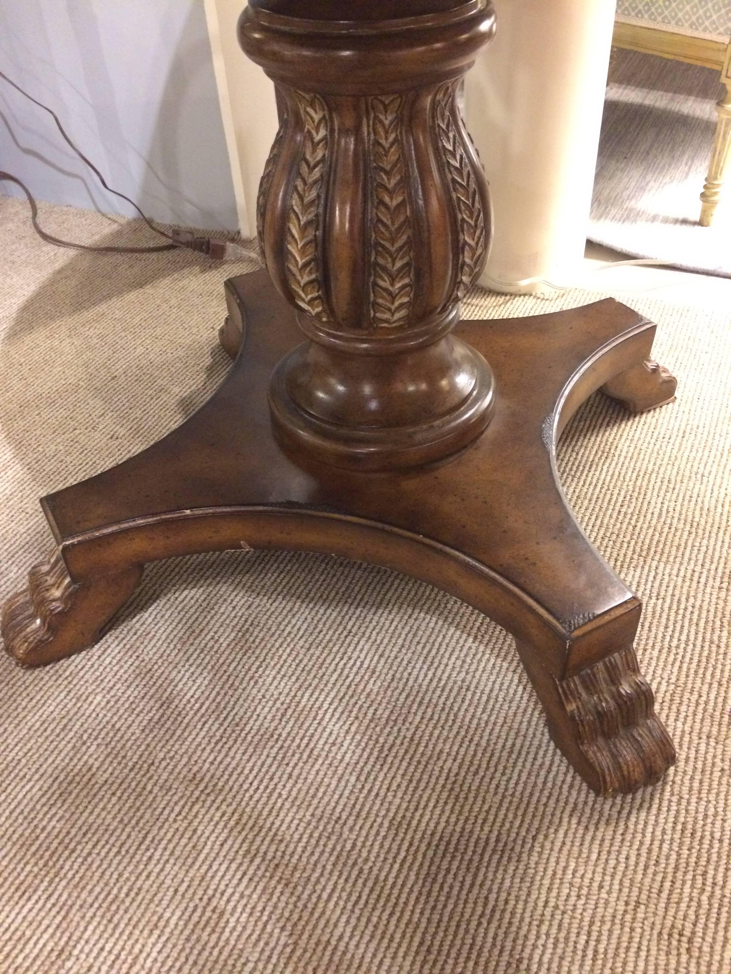 Striking round center or side table having gorgeous carved wood pedestal and claw foot base, topped with a wonderfully graphic black marble surface with white, grey and black star decoration.