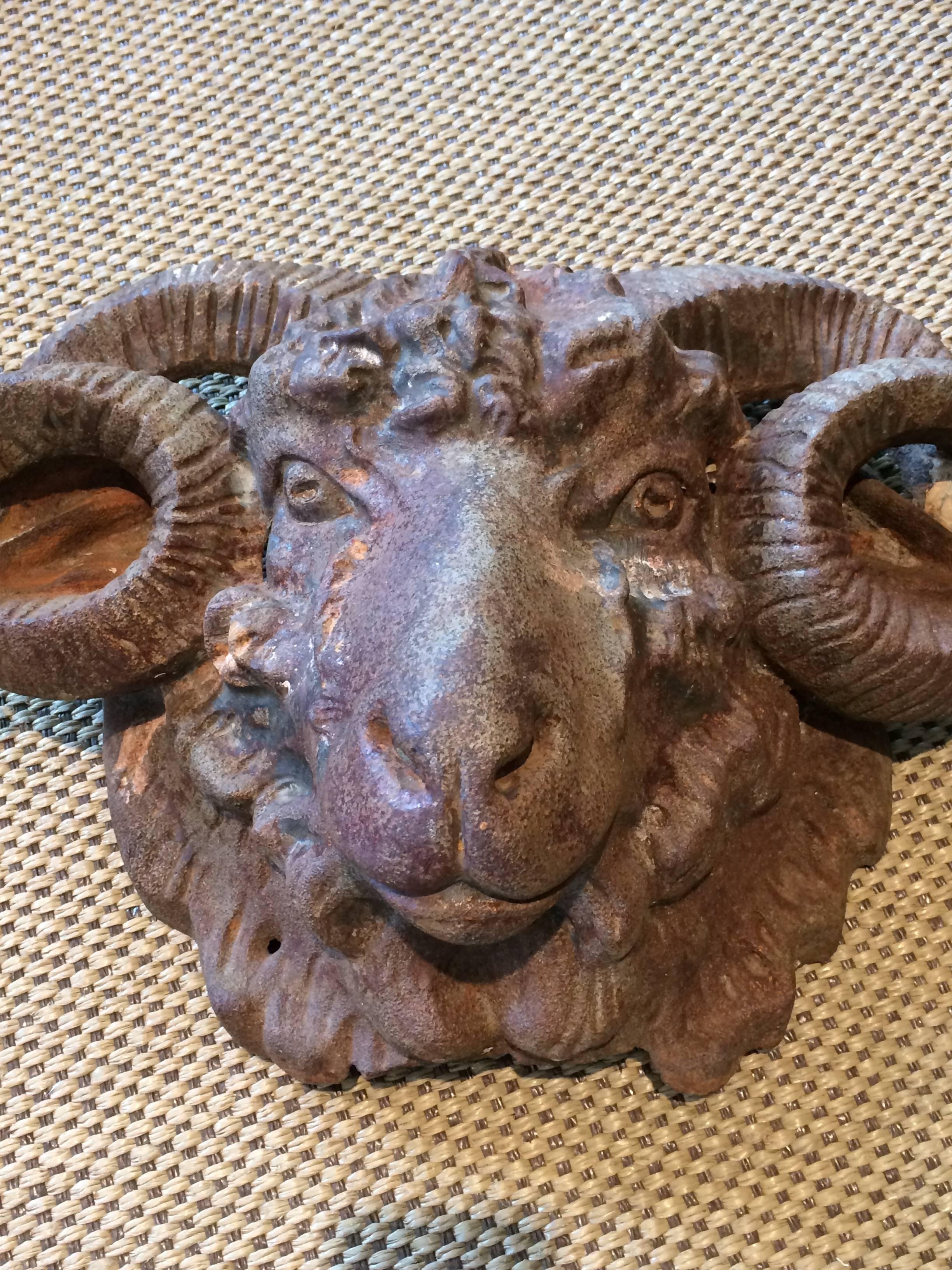 A very impressive heavy iron found object in the shape of a handsome ram's head with a natural aged rust colored patina.
