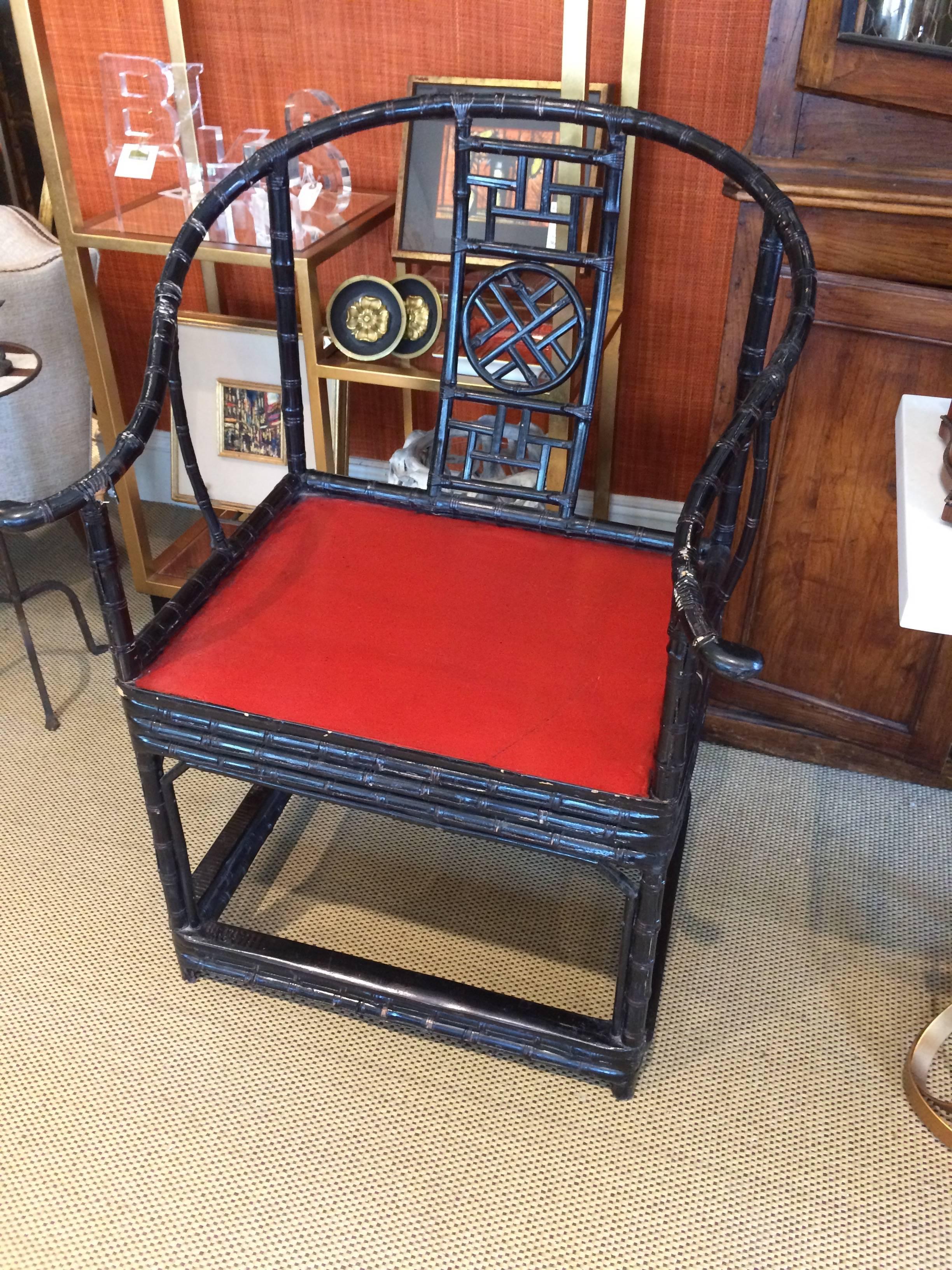 Black and red Chinese chairs having ebonized bamboo frames with wonderful geometric decoration on the backs and a red wooden seat.