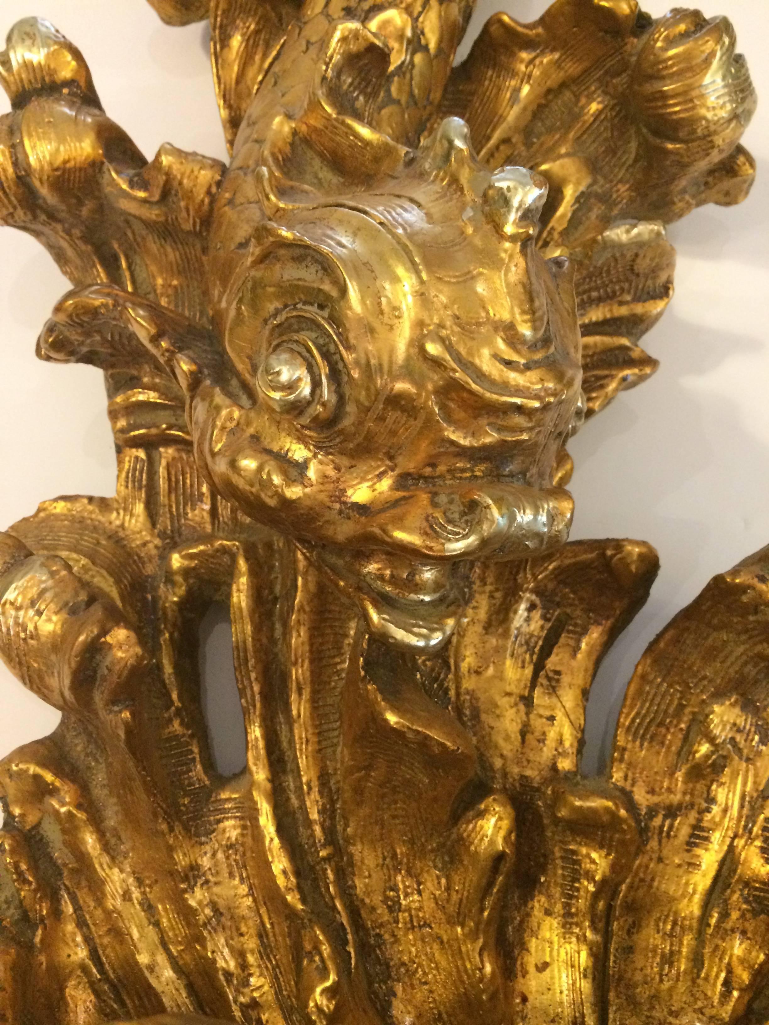 Dramatic gilded syrocco wood wall planter or sculpture having a Tony Duquette glamorous style, with central dolphin/fish among wave like curls.