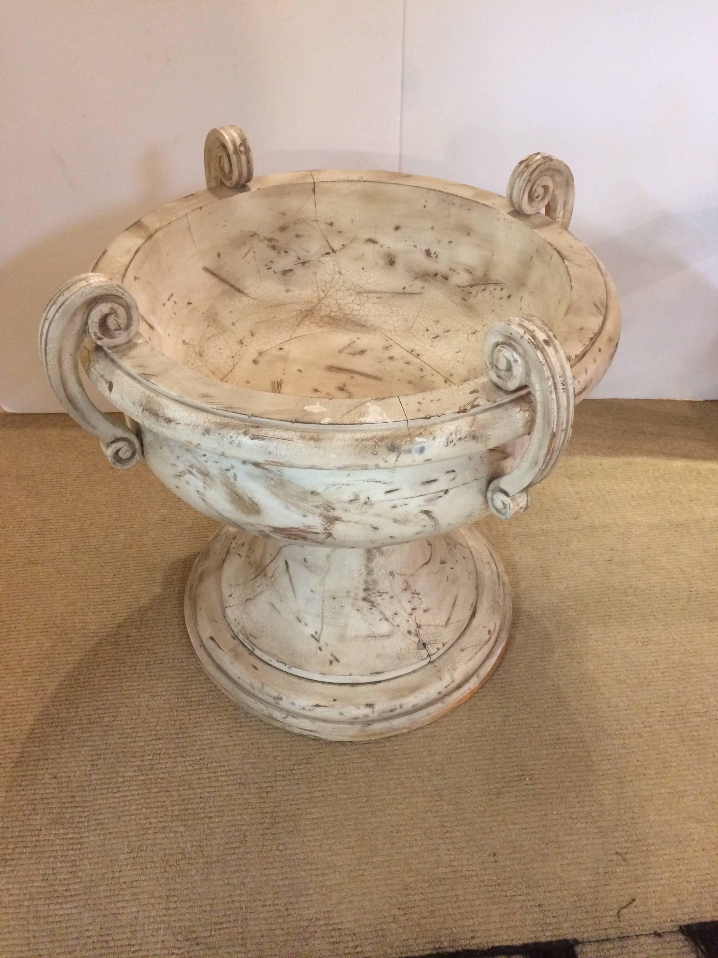 Neoclassical style large carved wood urn shaped table base having a sandy natural distressed finish and curved carved handles. Shown with 40