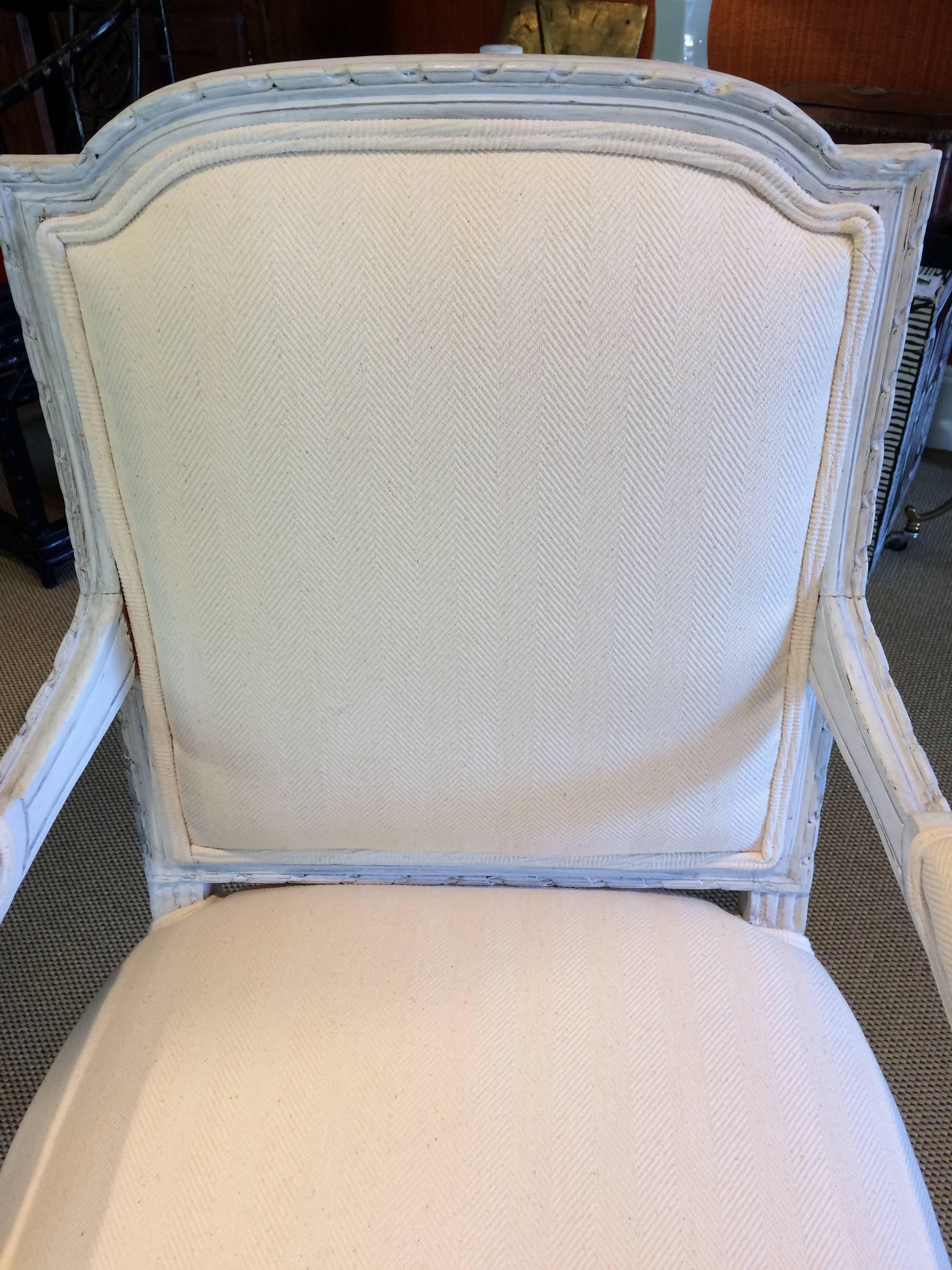Two sublime French armchairs having painted carved wood frames with acanthus leaves and reeded legs, in a soft Gustavian grey. Newly redone in tone on tone off white herringbone cotton canvas fabric. Seat height 20
arm height 28.5.