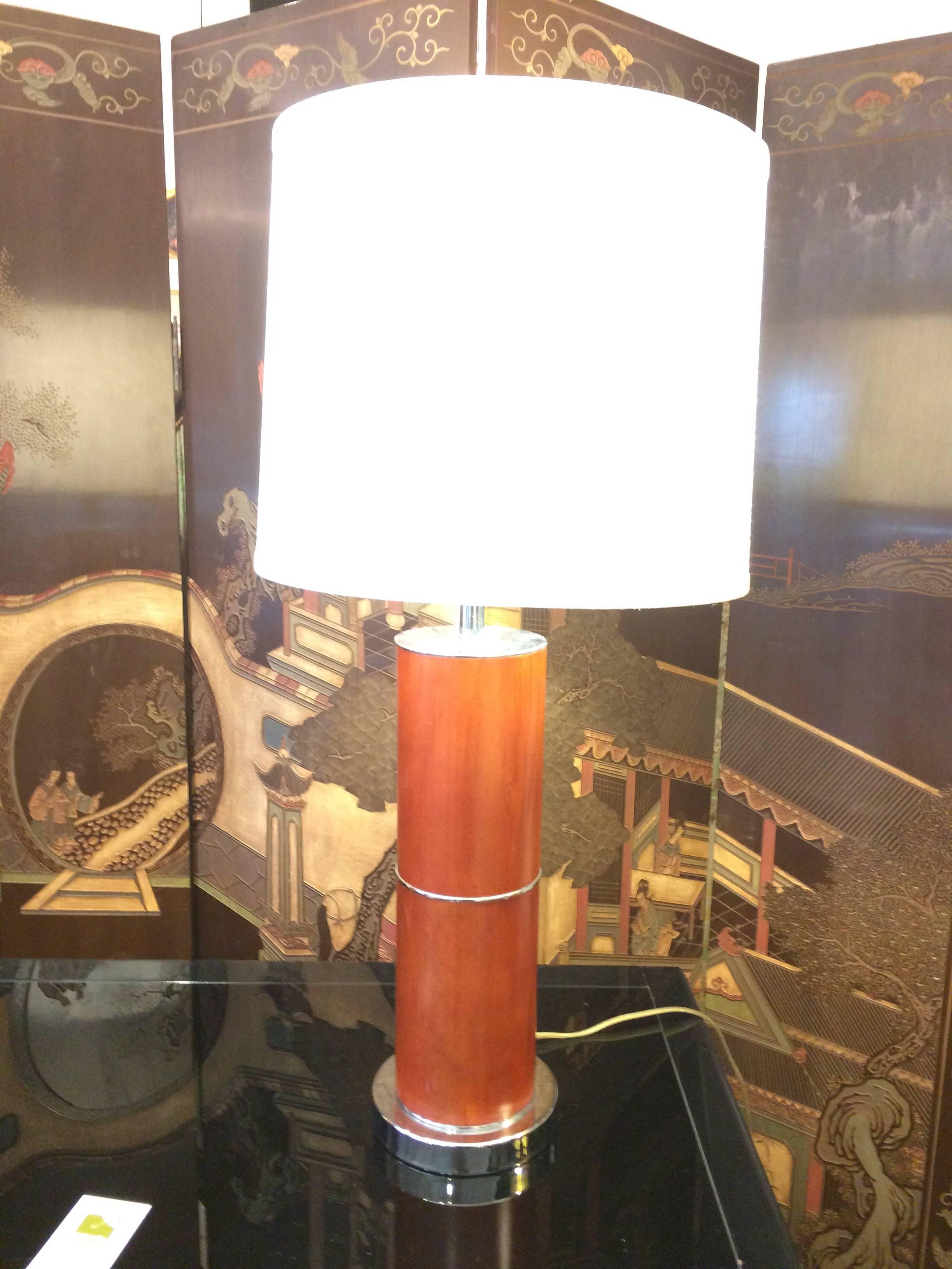 Handsome and clean lines describe this pair of burled wood and chrome columnar lamps. Custom shades; ball finials.
Measure: 6 inch diameter base.