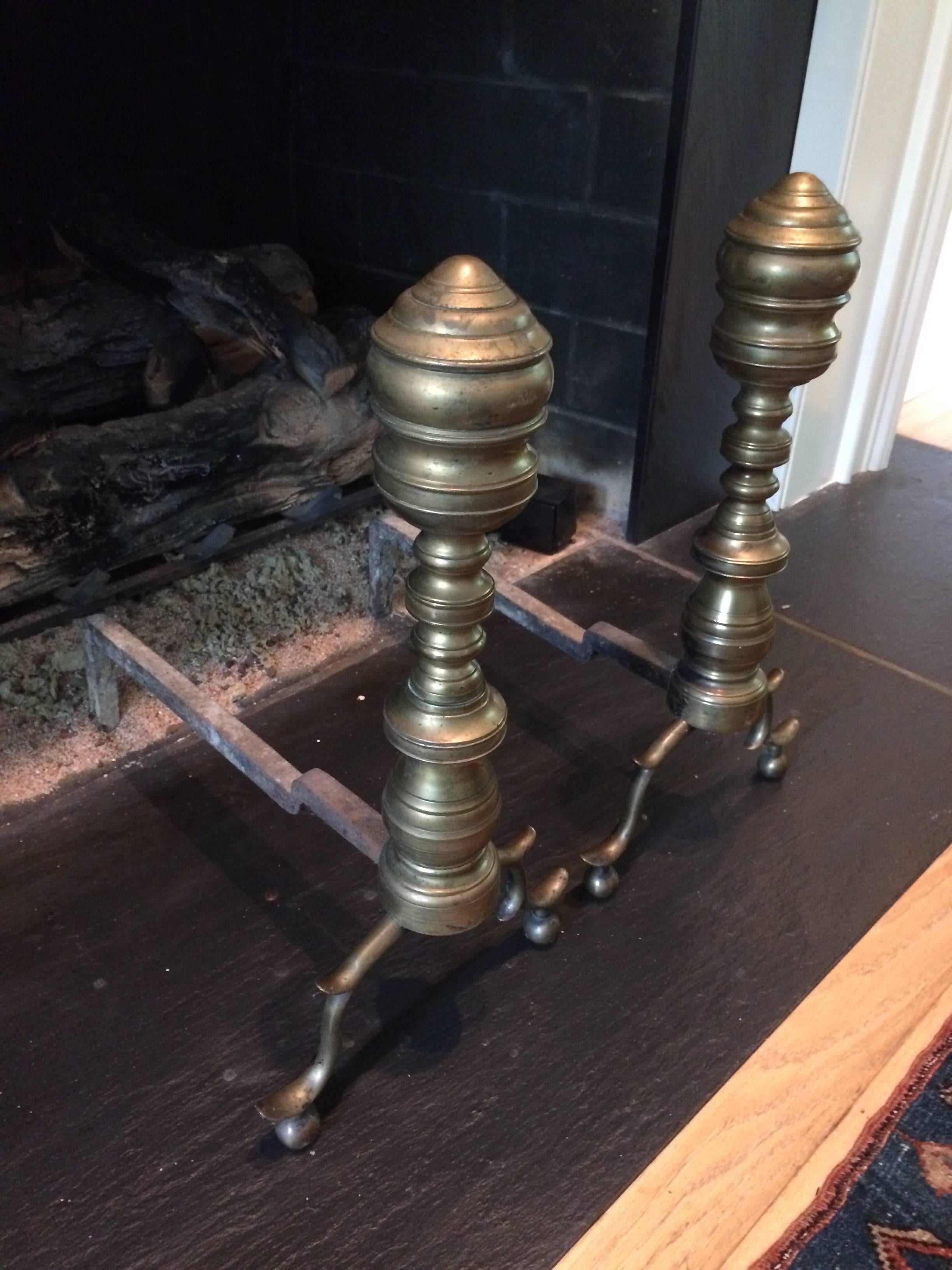 Classic pair of antique andirons in a aged brass.
