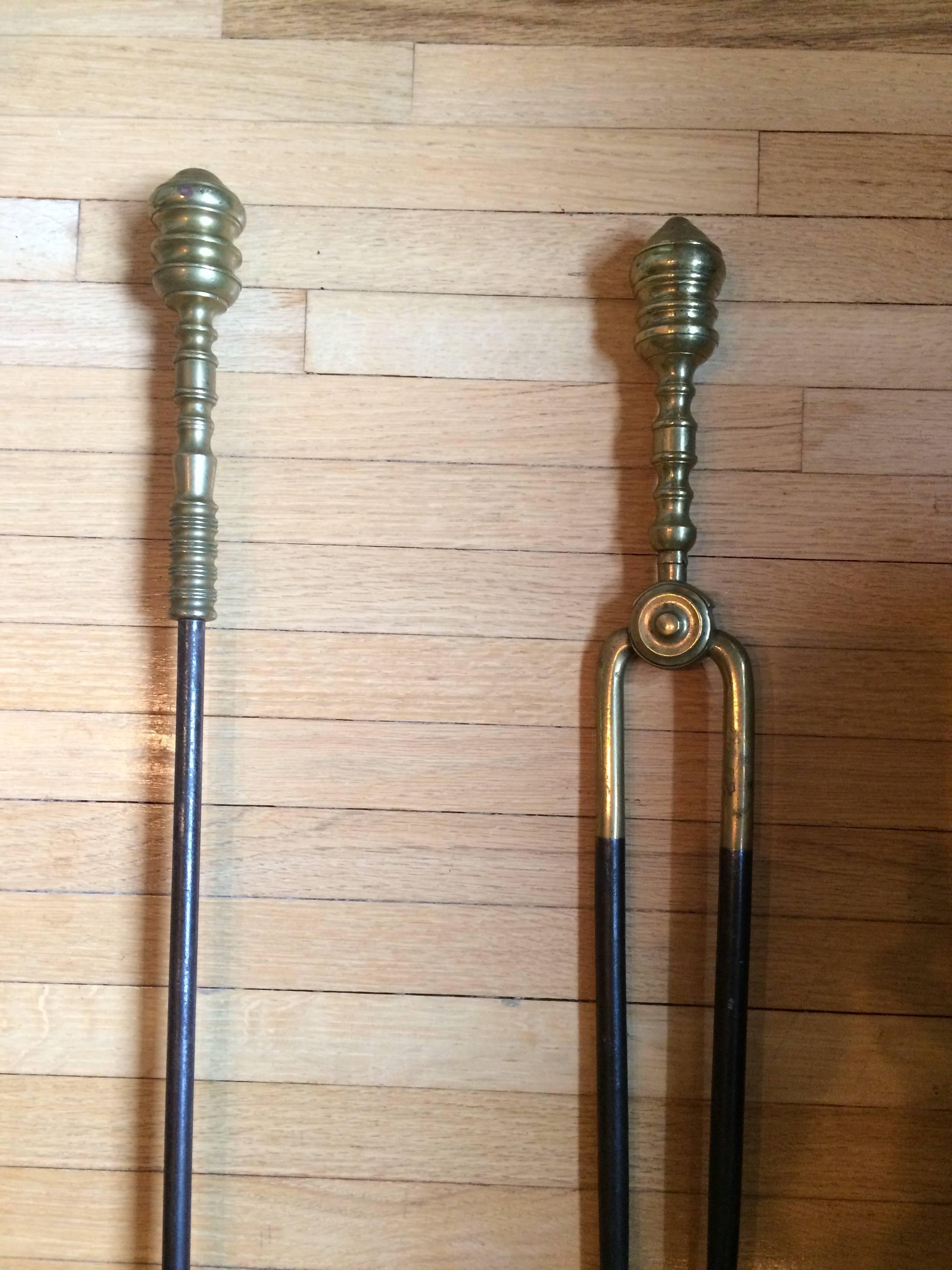 A handsome pair of iron and brass fireplace tools. One is a shovel; the other a pair of tongs. Measures: 29 H.