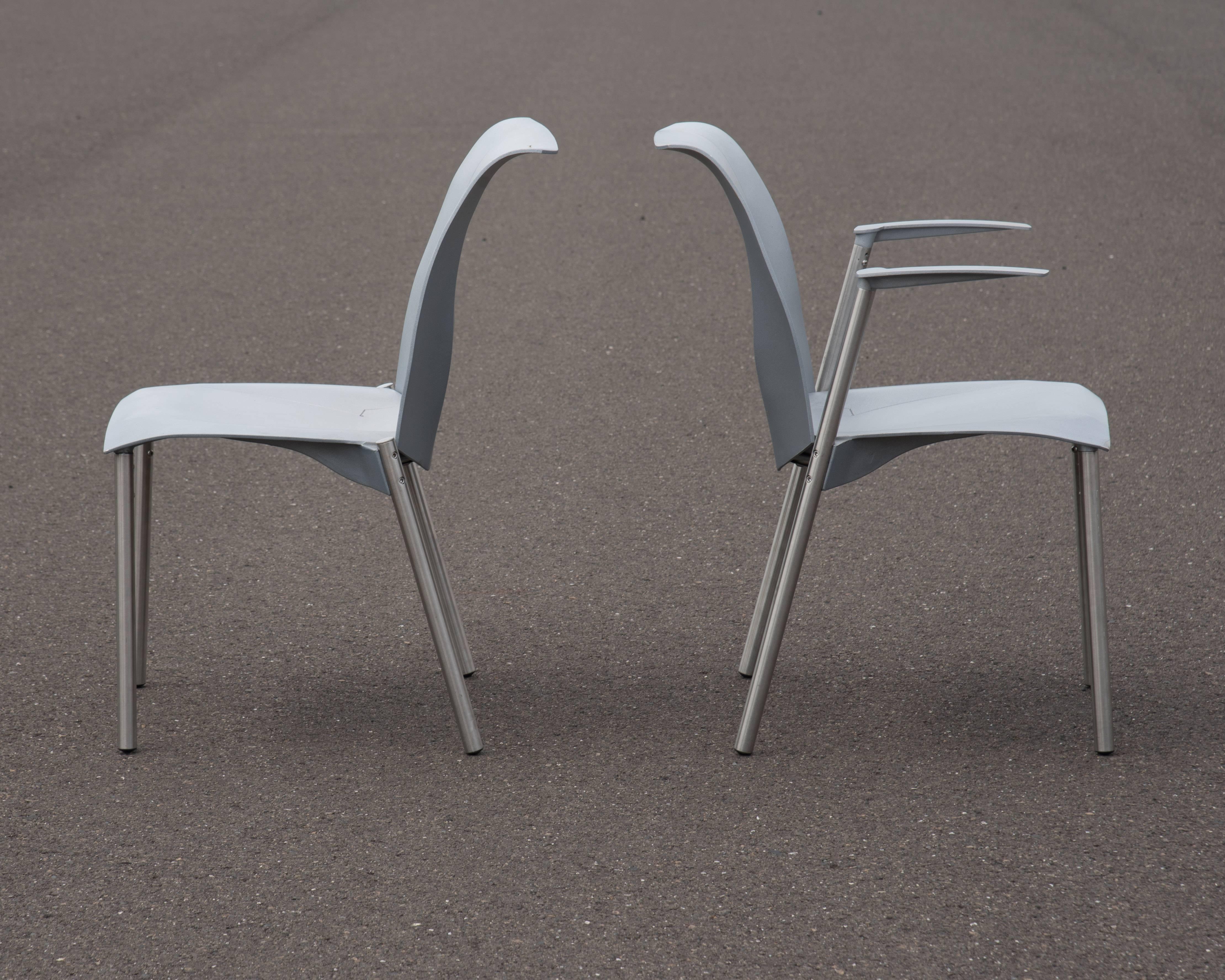 Two iconic fog chairs designed by Frank Gehry, one armchair and one side chair, these chairs were produced by Knoll, circa 1999. Metal stacking chairs that incorporate complex geometry and a urethane spring mechanism that adds flex and comfort. Can