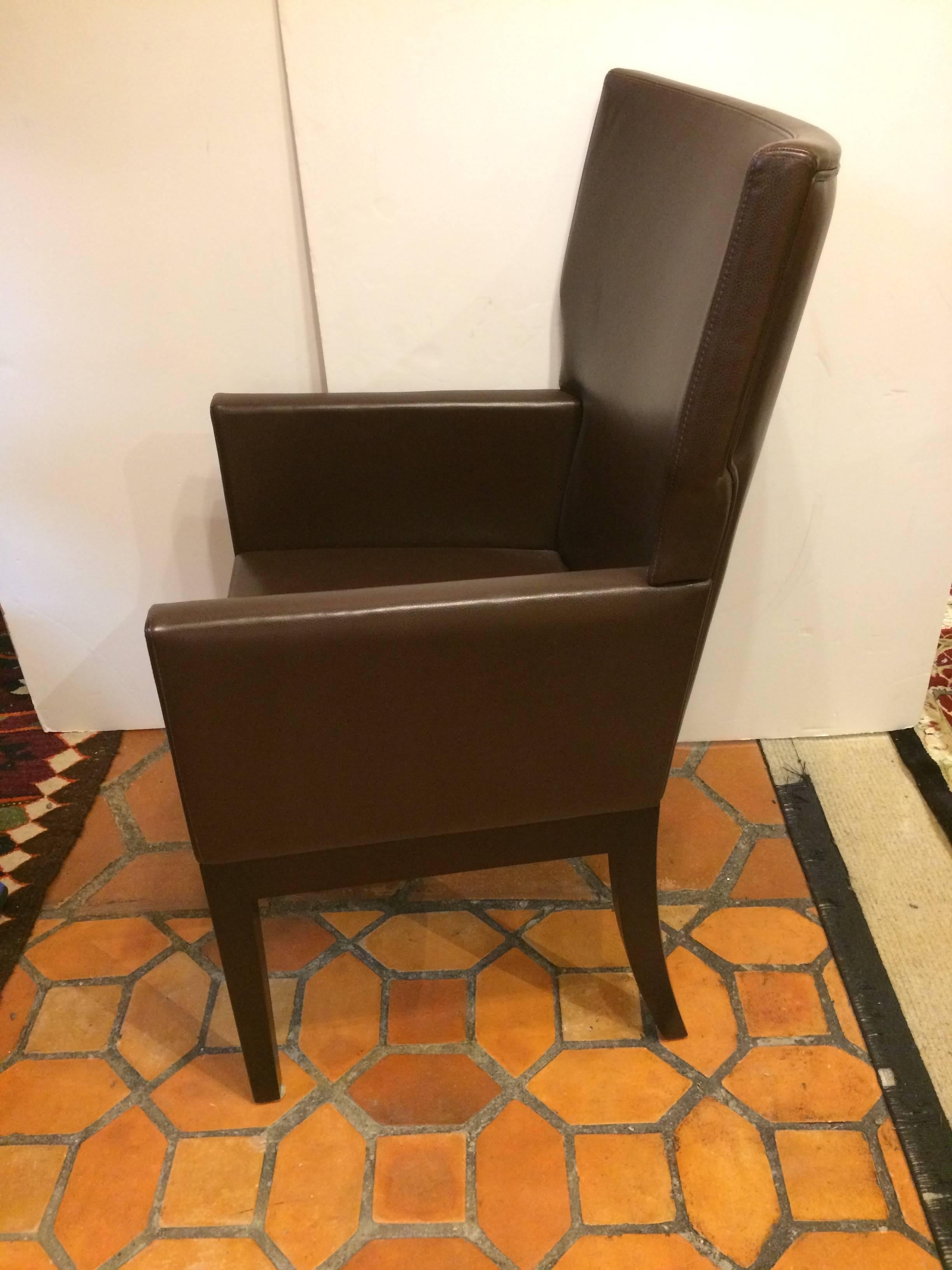 Very smart pair of high quality chocolate brown leather arm chairs having custom tapered mahogany ebonized legs. Label underside says Christian Liagre. These are available new to the trade for $7500 each. Can be used as dining chairs, club chairs or