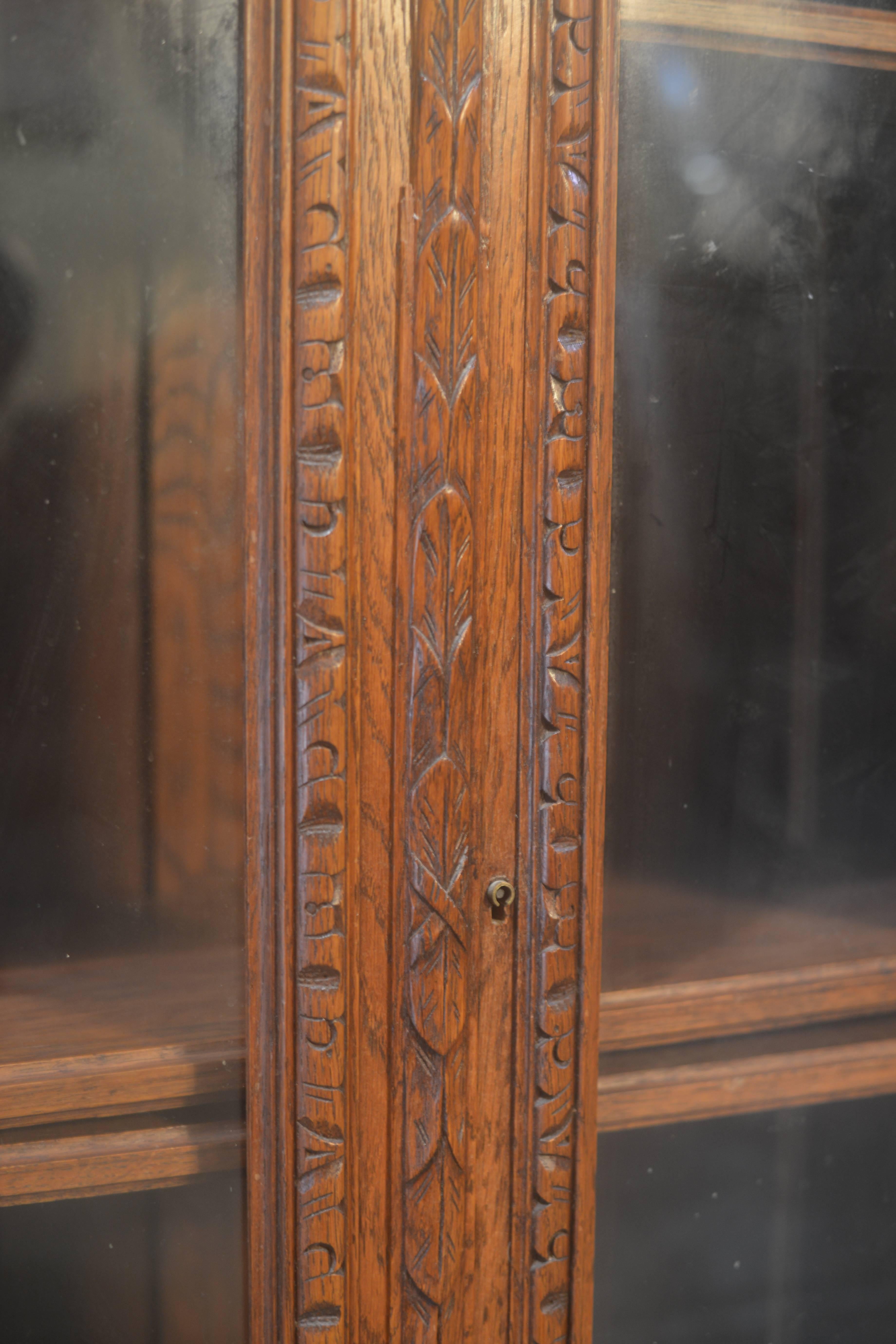 French antique bookcase or curio cabinet. Made of French oak, this bookcase features beautiful carvings. There are three adjustable shelves with original hardware. Great size, a piece that can fit in smaller spaces. Mint condition, circa 1890. 
