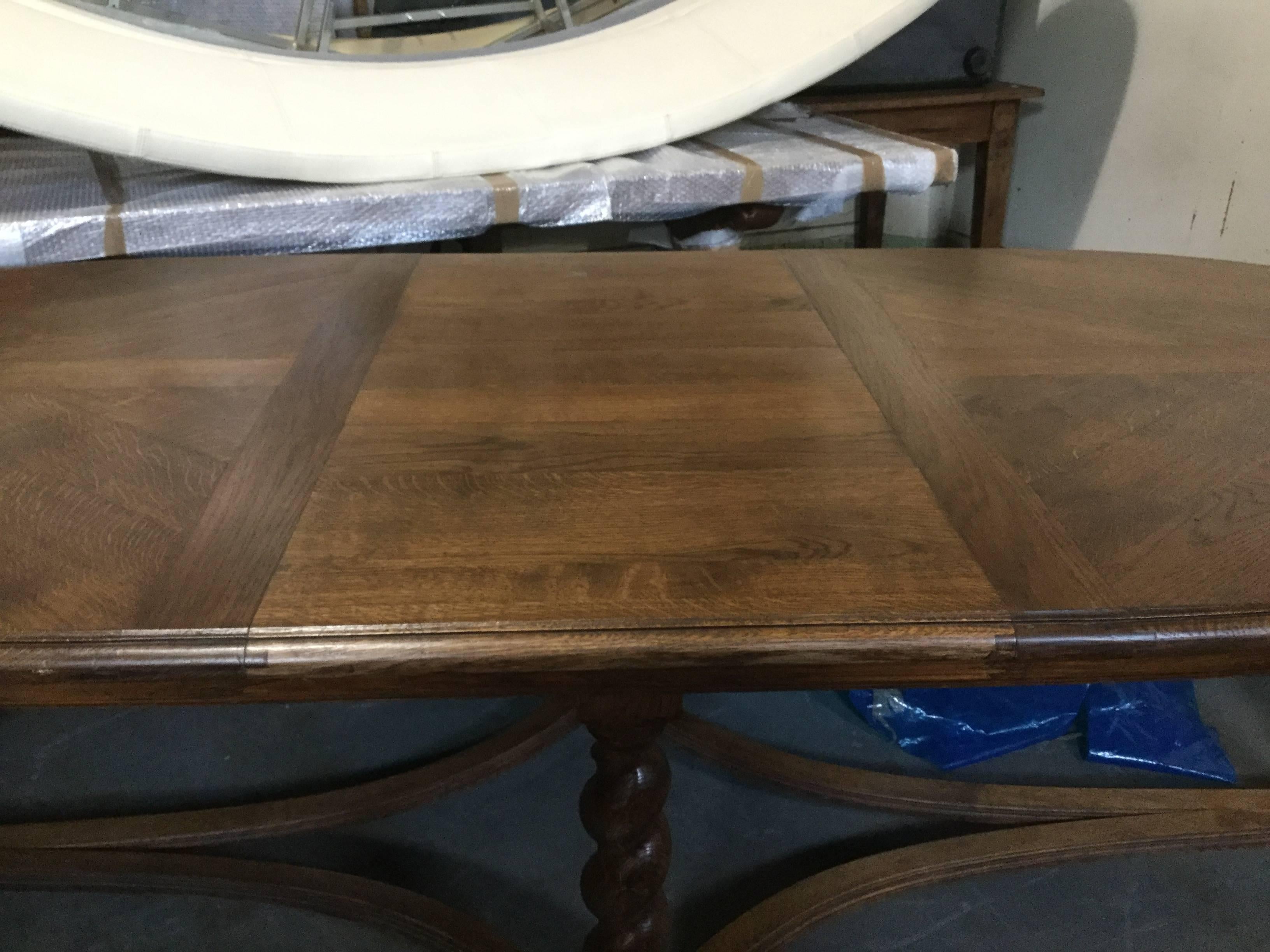 French antique oval dining table with barley twist legs. This large table features a beautiful parquet top over barley twist legs and can easily seat ten. Made of French oak, circa 1910.