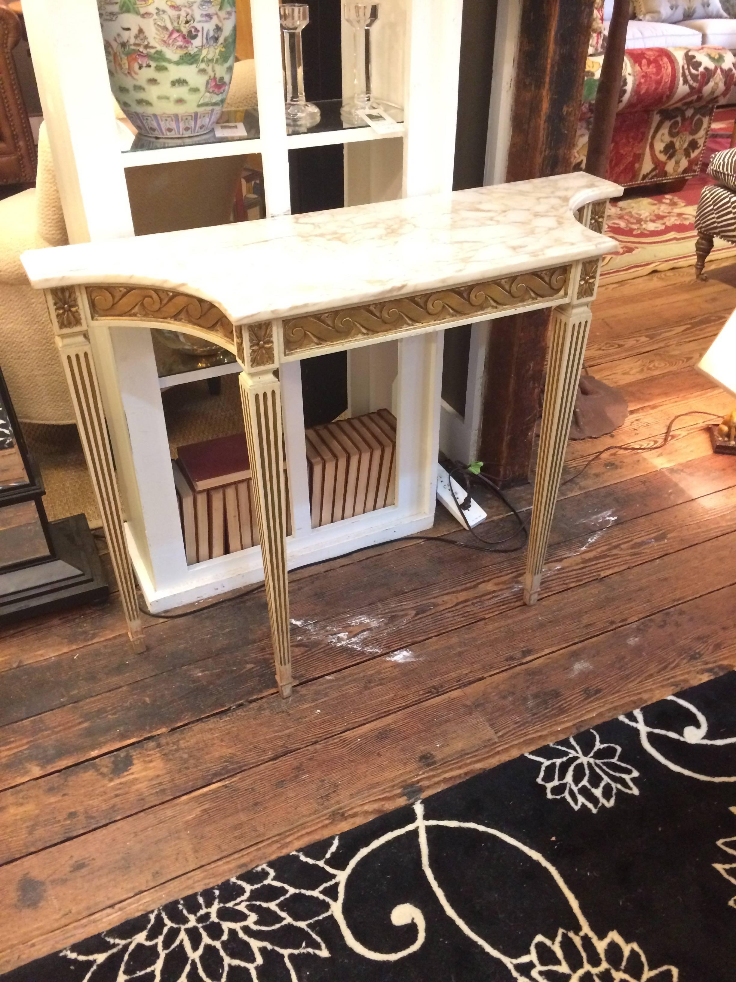 Narrow French console with carved and painted base in gold and cream with lovely tapered legs, topped with creamy marble top.
