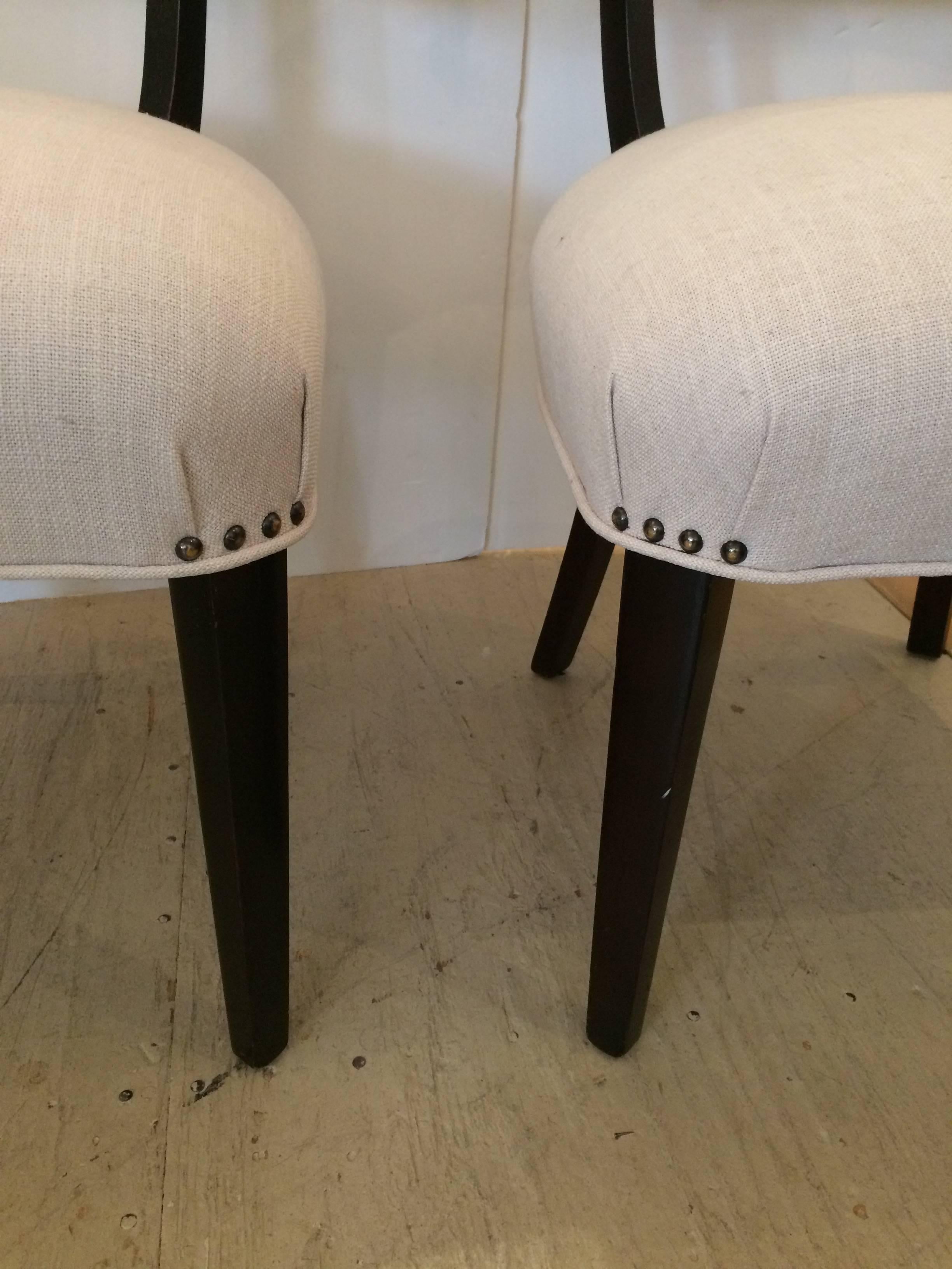 Two klismos style club chairs having ebonized mahogany legs and new linen upholstery.