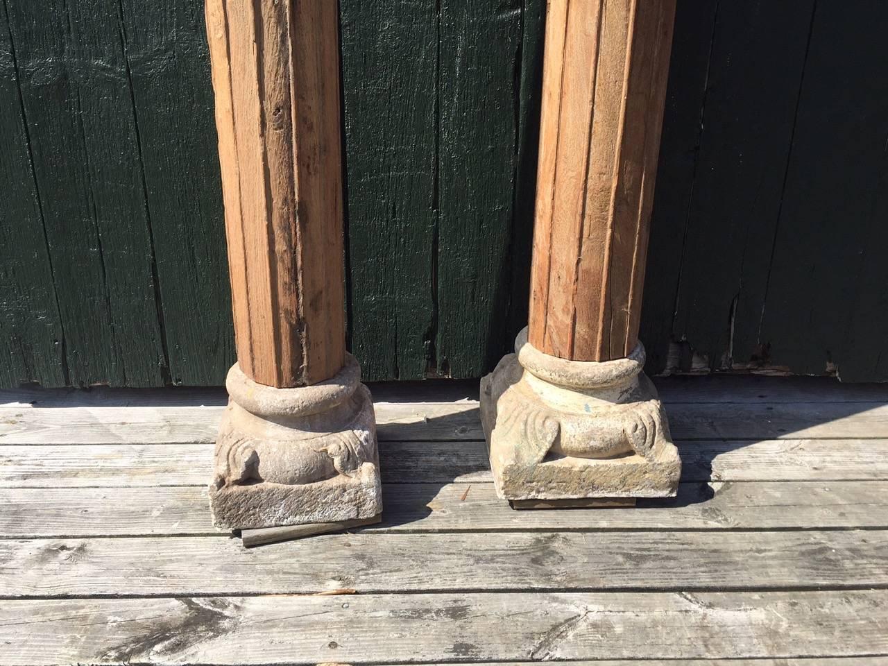 These are the very early and fabulous solid wood (we think walnut) carved columns with stone bases and carved wood tops. Measure: They are 8’8 ¼” tall. One of the tops has a piece of wood missing (see photo). Also the stone bases are slightly