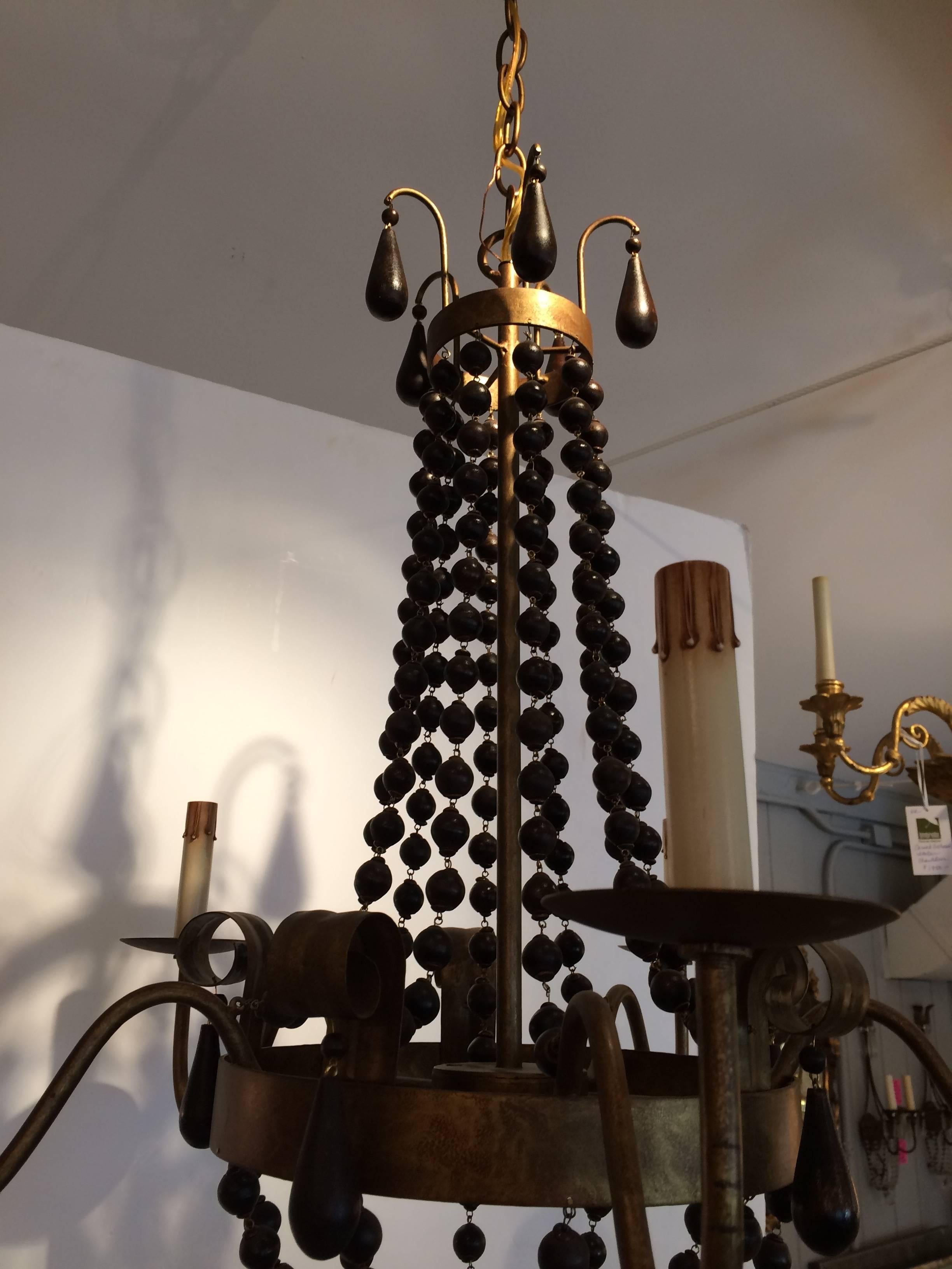 Great looking transitional chandelier having four iron arms and wonderful cascades of brown wooden beads to make an elongated elegant statement.